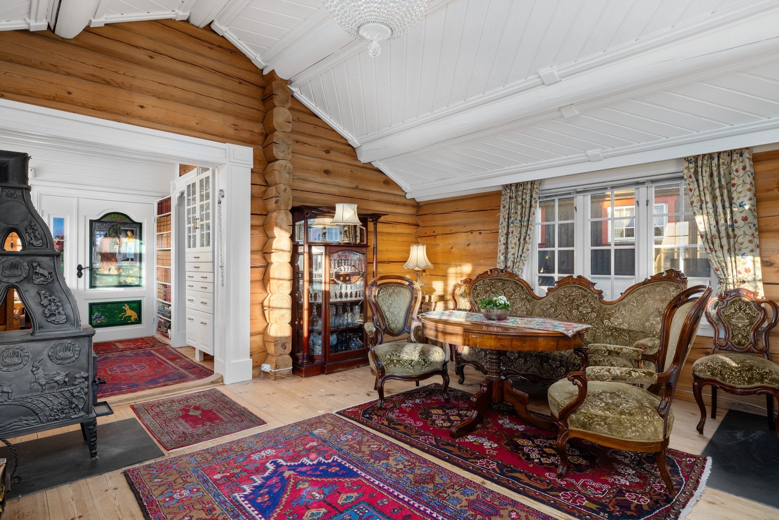 Stuen fremstår som et varmt og stemningsfullt oppholdsrom med laftede tømmervegger som gir en lun og tradisjonsrik atmosfære. Galleribilde