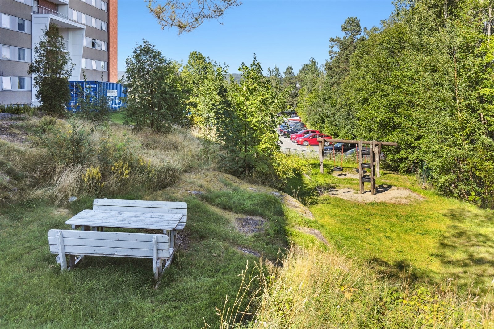 Felles tomt for borettslaget. Tomt er opparbeidet med plen, vei og parkeringsareal. Galleribilde