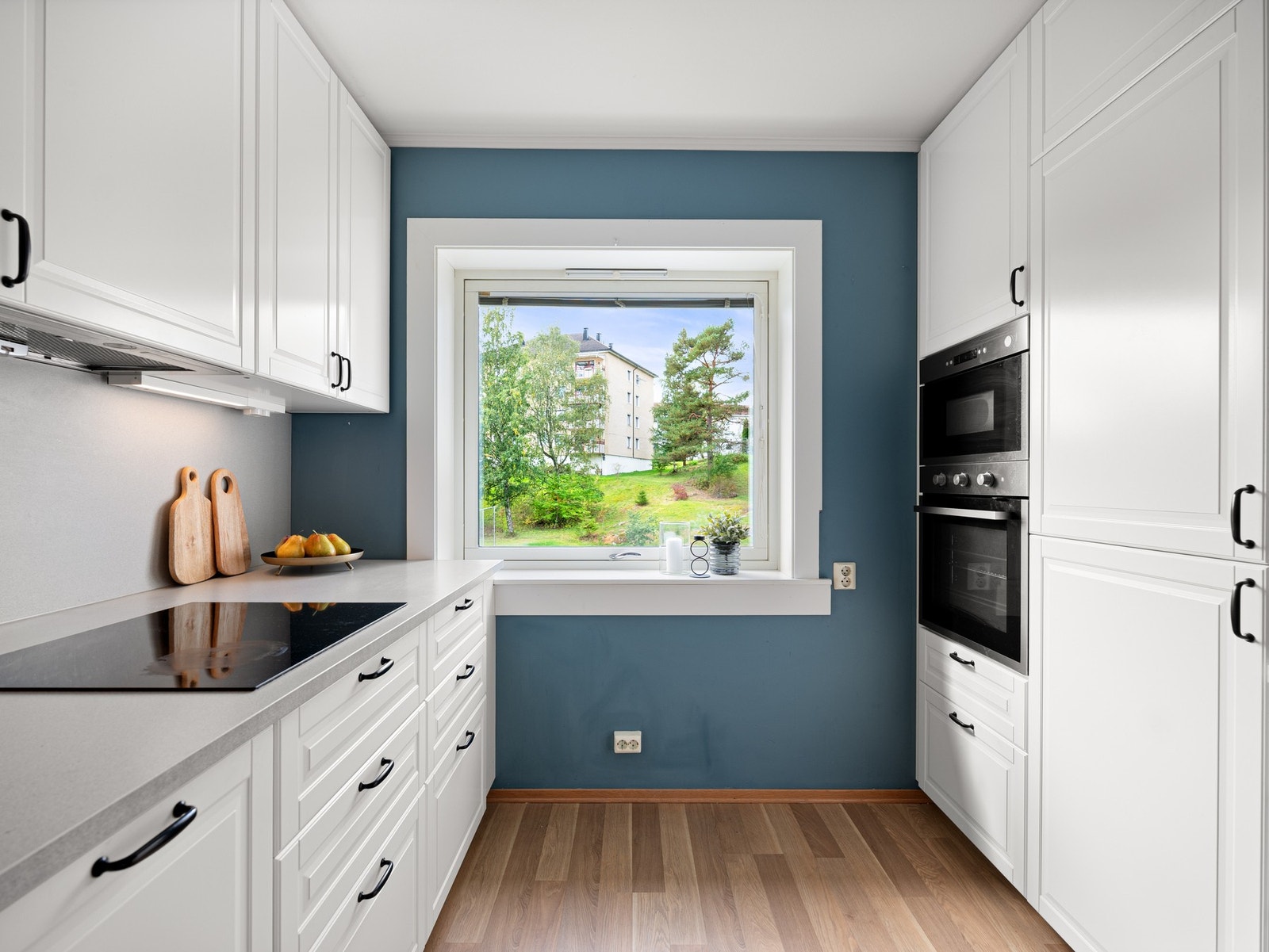 Godt med skap og benkeplater. Benkeplater og sprutsoner i laminat. To store vitrineskap med belysning. Galleribilde