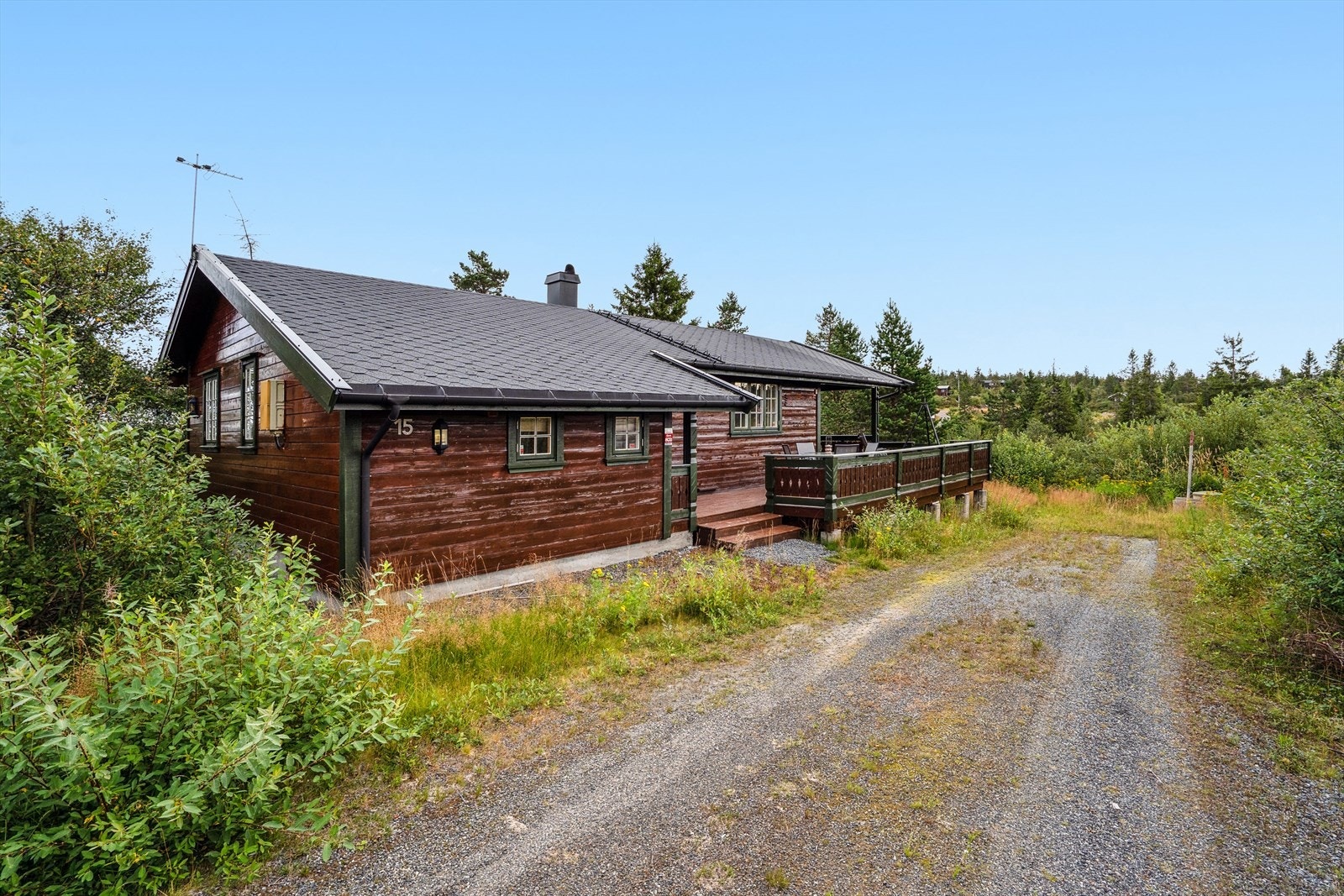 Eiet tomt opparbeidet med treterraser og plen, resterende er naturtomt. Galleribilde