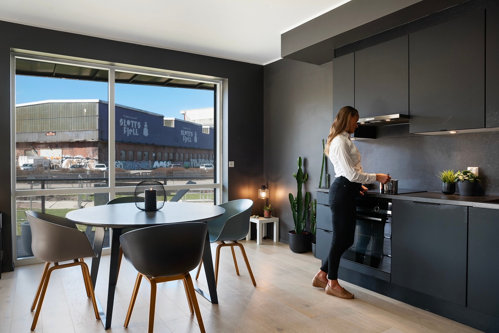 Lekker sort kjøkkeninnredning med sorte integrerte hvitevarer Galleribilde