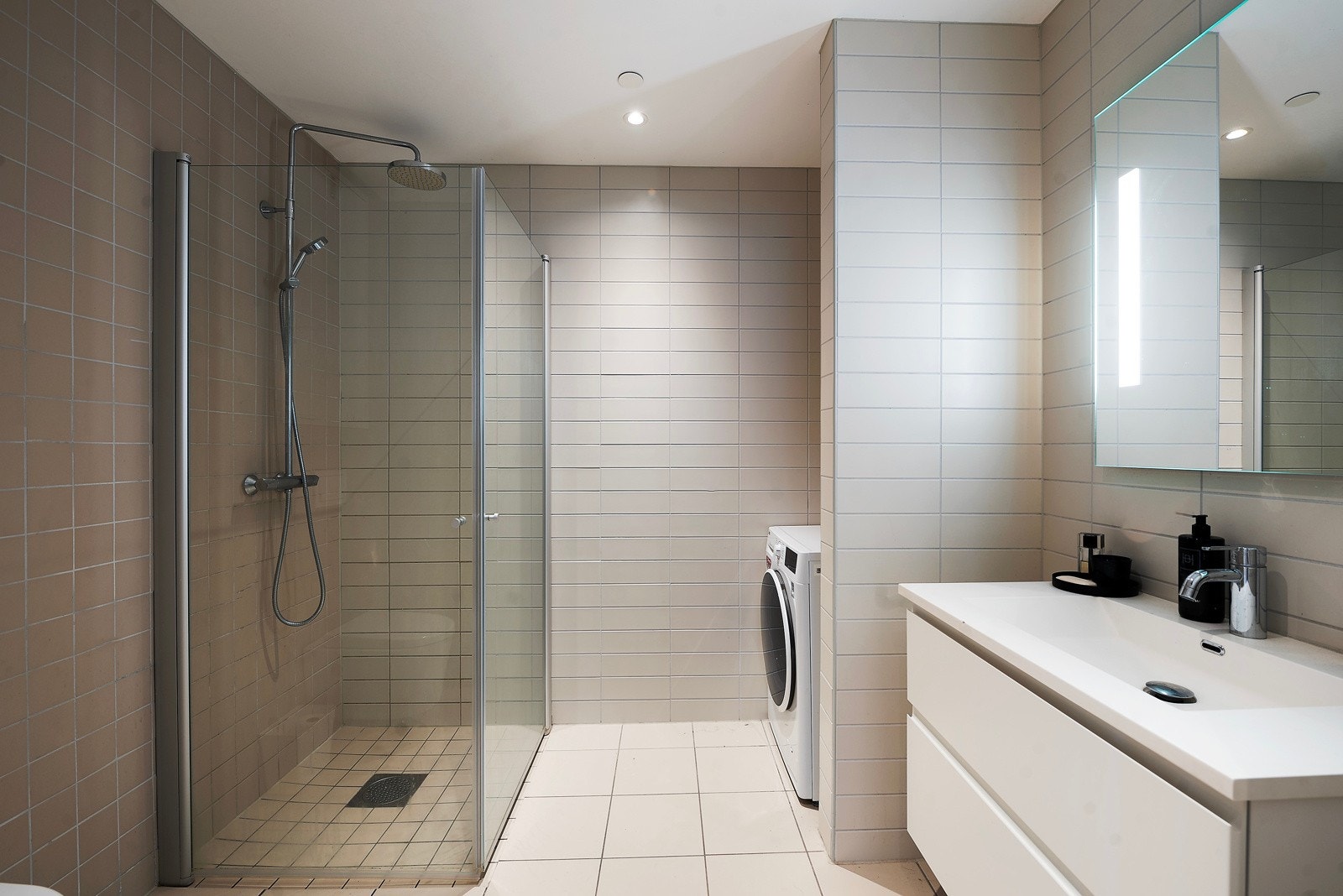 Lekkert helfliset bad med vegghengt toalett, lekker baderomsinnredning og dusjhjørne Galleribilde