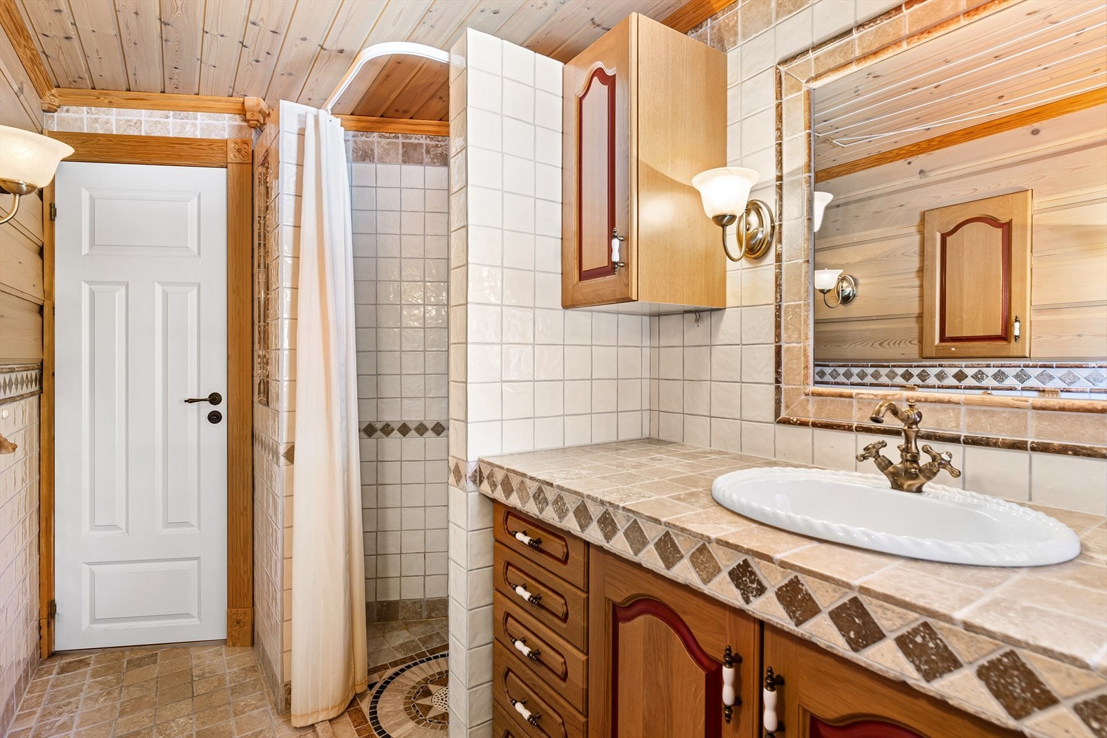 Pent flislagt bad 2 som har varmekabler i gulv med elegant servant innredning og speil. Galleribilde