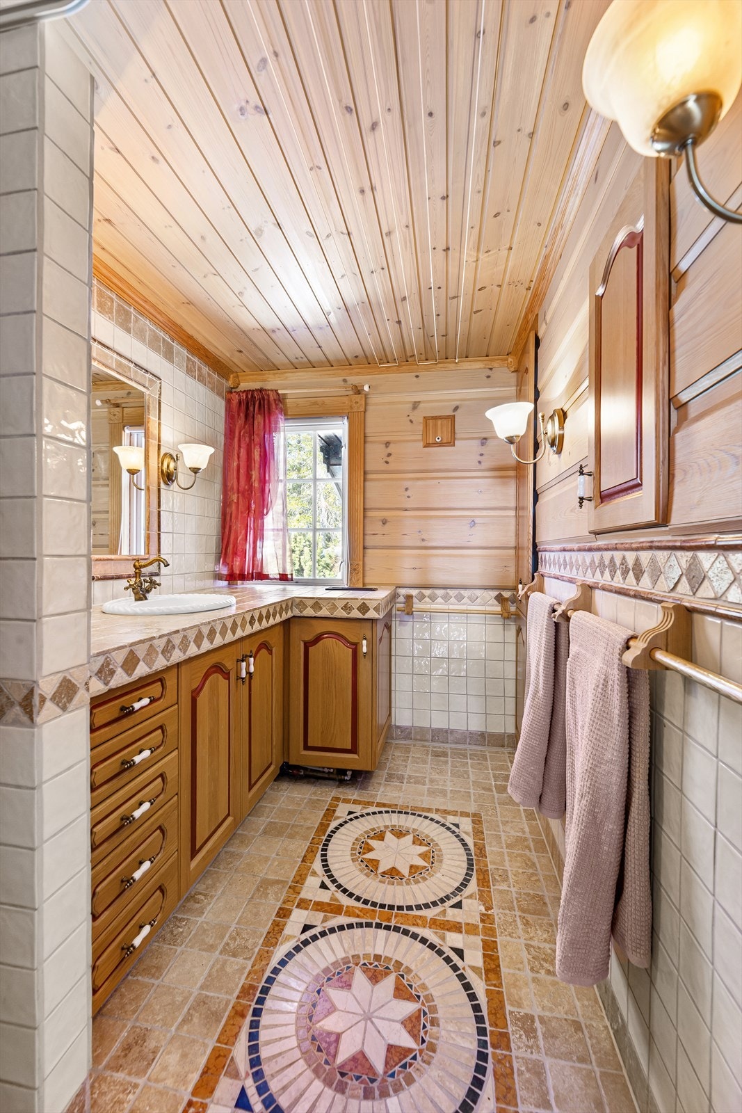 Badet er innredet med dusjnisje og romslig baderomsinnredning med servant. Galleribilde