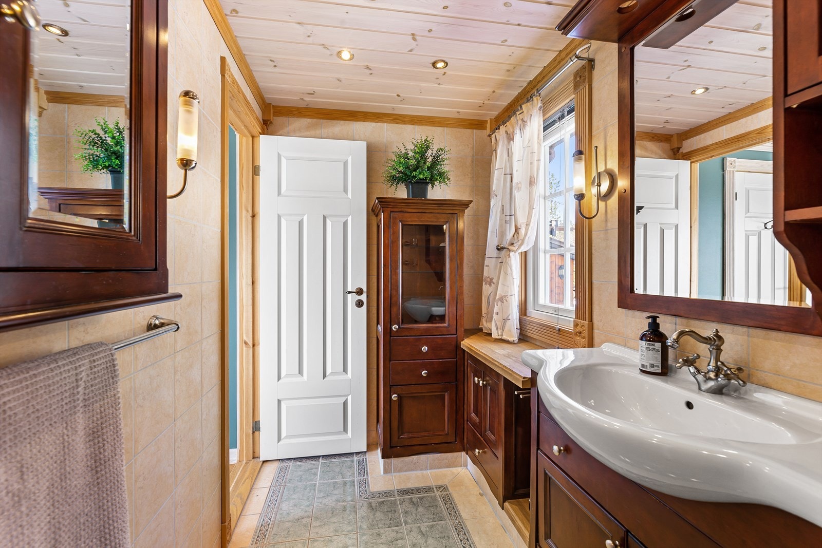 Badet er innredet med servant, dusjhjørne og baderomsinnredning. Galleribilde