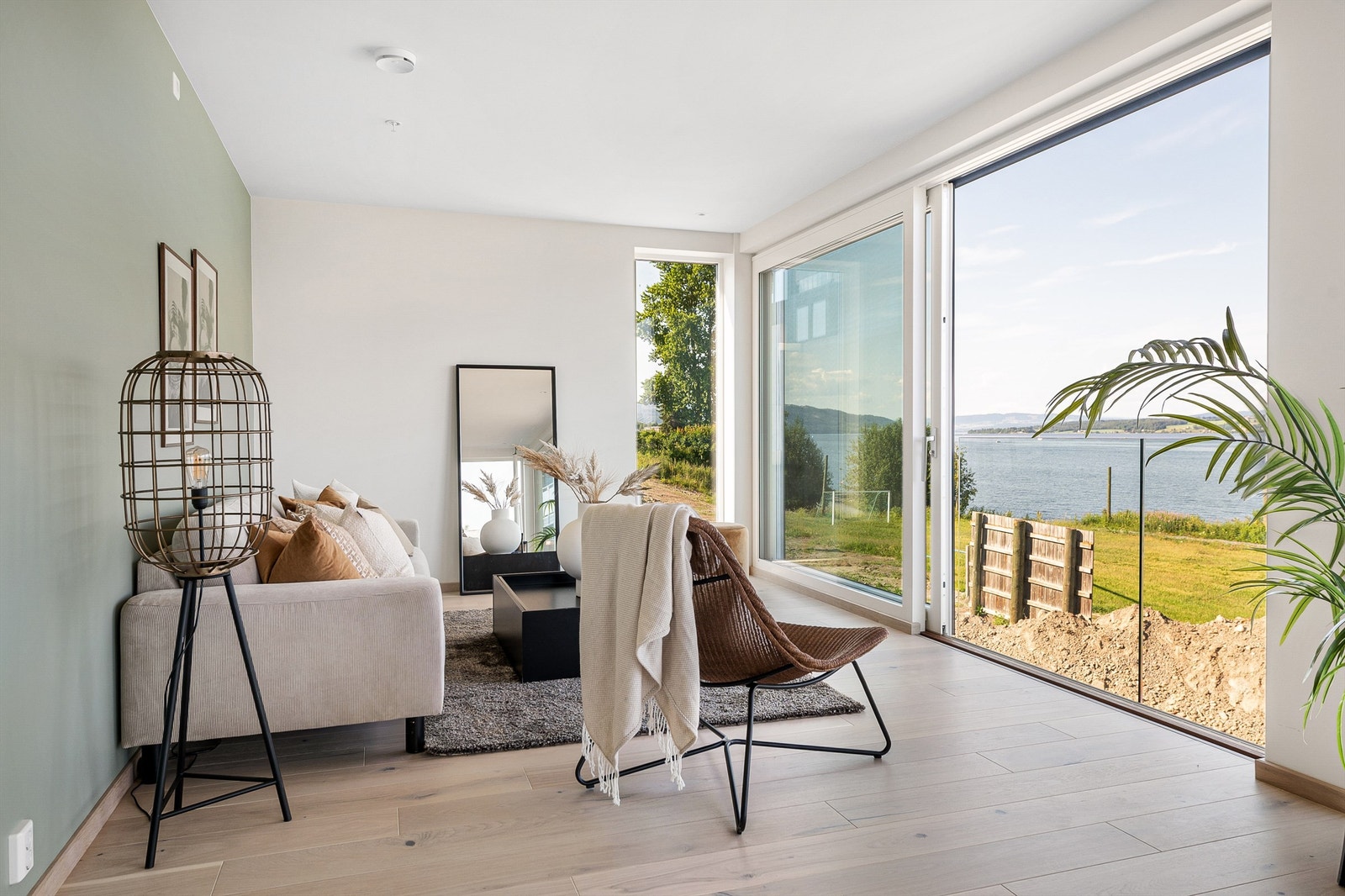 Stor stue i underetasje med store balkongdører som slipper inn både lys og luft Galleribilde