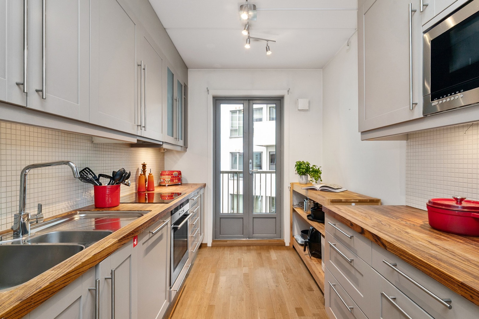 Kjøkken med integrerte hvitevarer som stekeovn, platetopp og oppvaskmaskin. Frittstående kjøleskap. Galleribilde