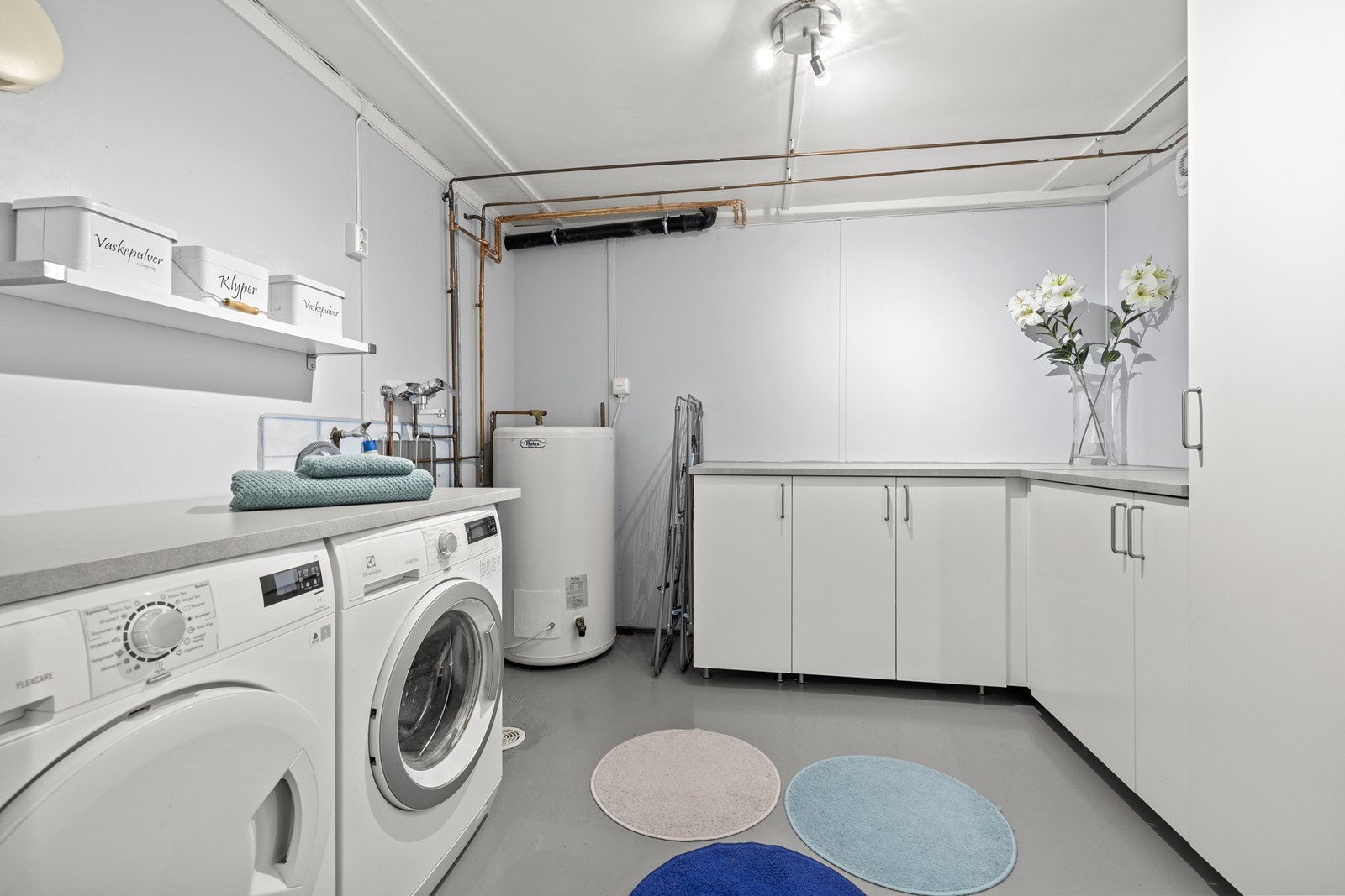 Stort og praktisk vaskerom med rikelig benkeplass og opplegg for vaskemaskin. Galleribilde