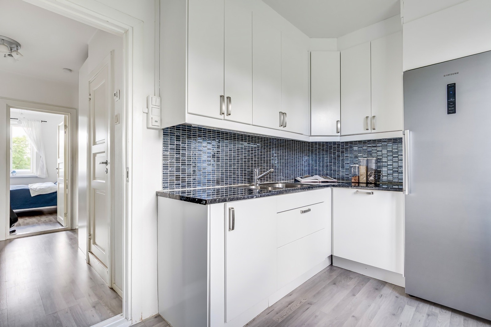 Tidløs innredning med hvite, glatte fronter og benkeplate i laminat. Galleribilde