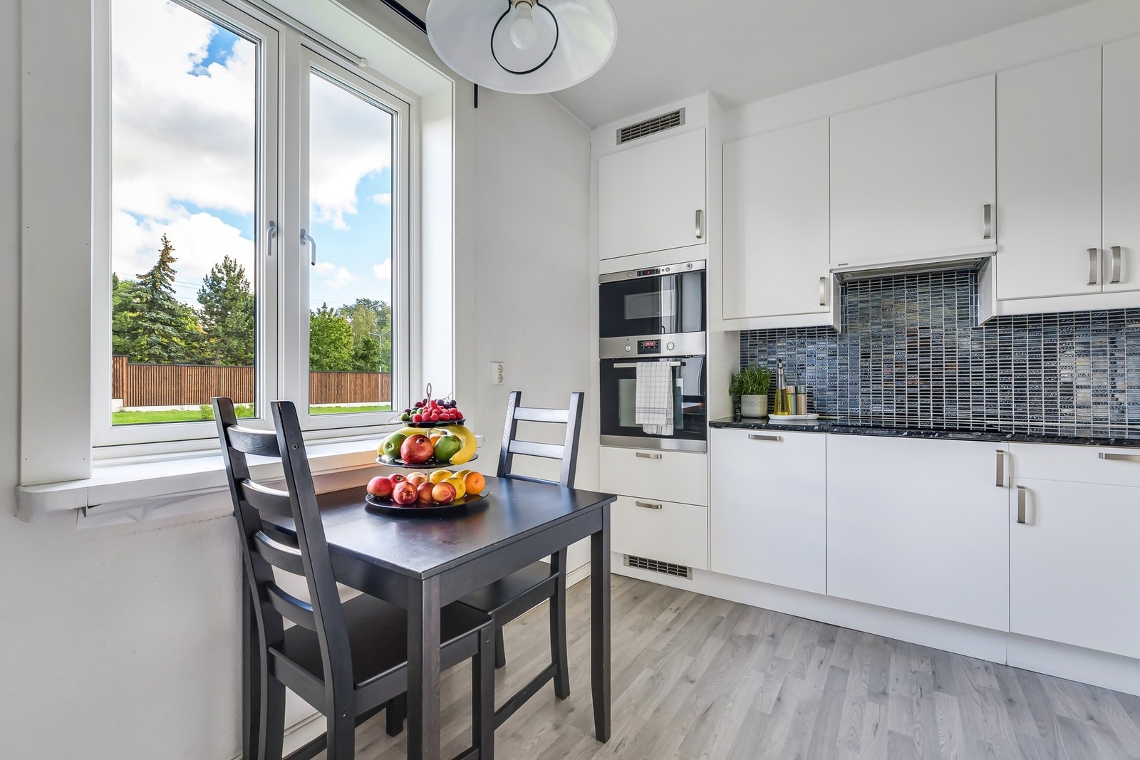 Kjøkkenet har stilige fliser på vegg over benken. Galleribilde