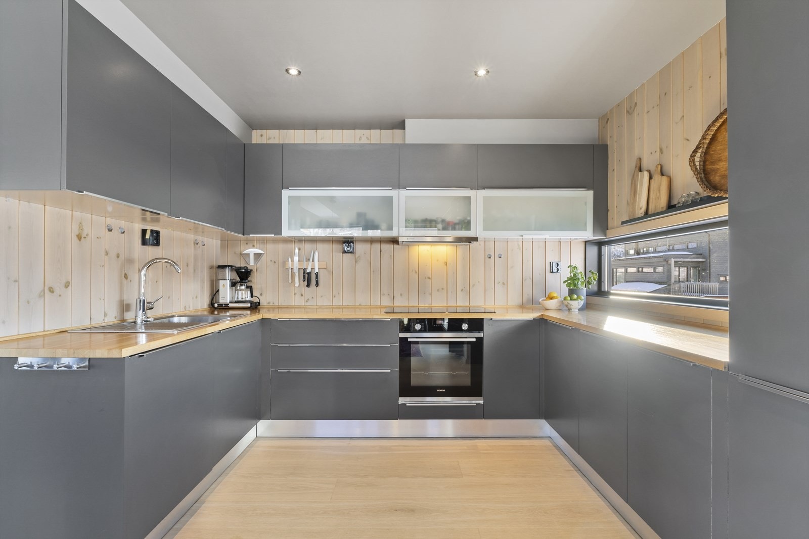 Moderne kjøkken med stilrene løsninger og plass til både matlaging og sosialt Galleribilde