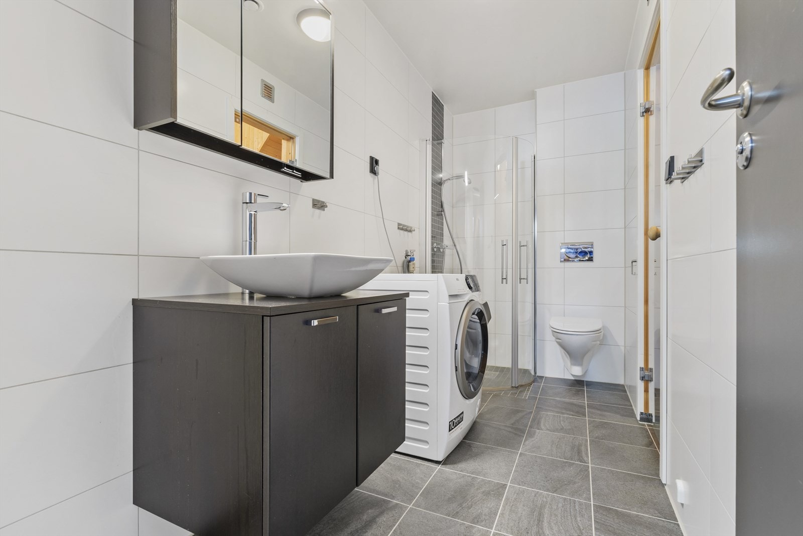 Moderne bad med stilrene fliser og funksjonelle løsninger, perfekt for etter en aktiv dag Galleribilde