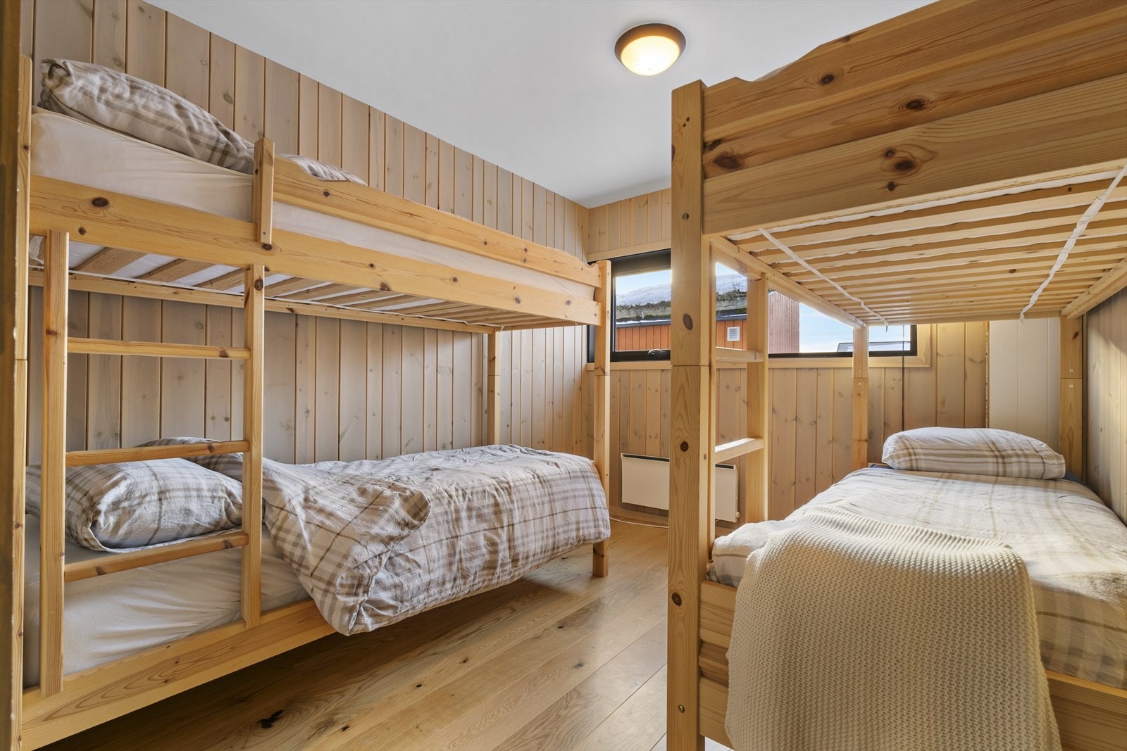 Romslig soverom som gir plass til flere senger og innredning Galleribilde