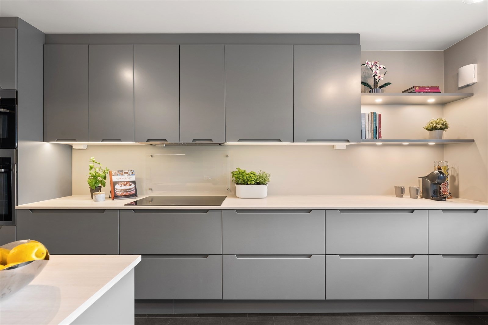 Lekker ny kjøkkeninnredning fra HTH med slette lakkerte fronter, laminat benkeplate med glassplate over kokesonen, planlimt oppvaskkum av kompositt e.l og ventilator med utluft. Galleribilde