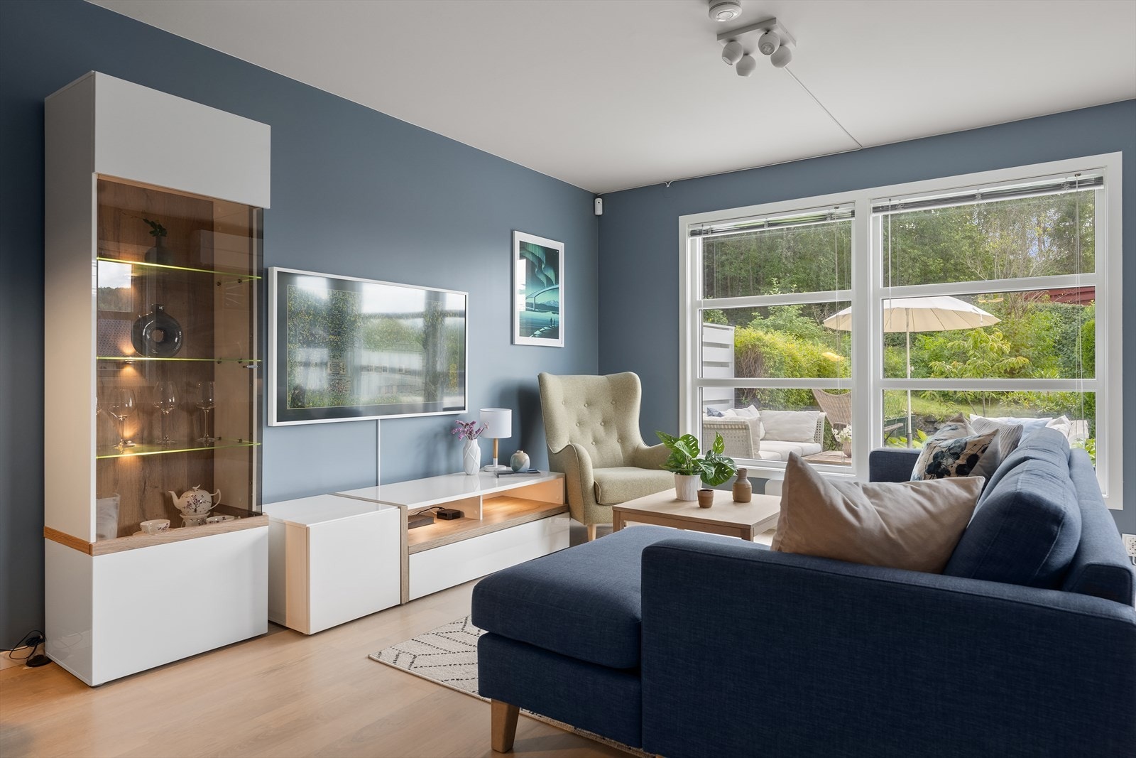 Den romslige stuen gir plass til både en innbydende sofagruppe og funksjonelt medie-/oppbevaringsmøblement. Galleribilde