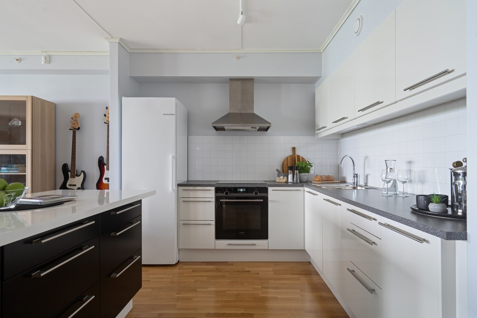 En praktisk øyløsning forlenger arbeidsflaten og gir ekstra oppbevaringsplass. Dette gir gode rammer for matlaging i sosialt lag med familie og venner. Galleribilde