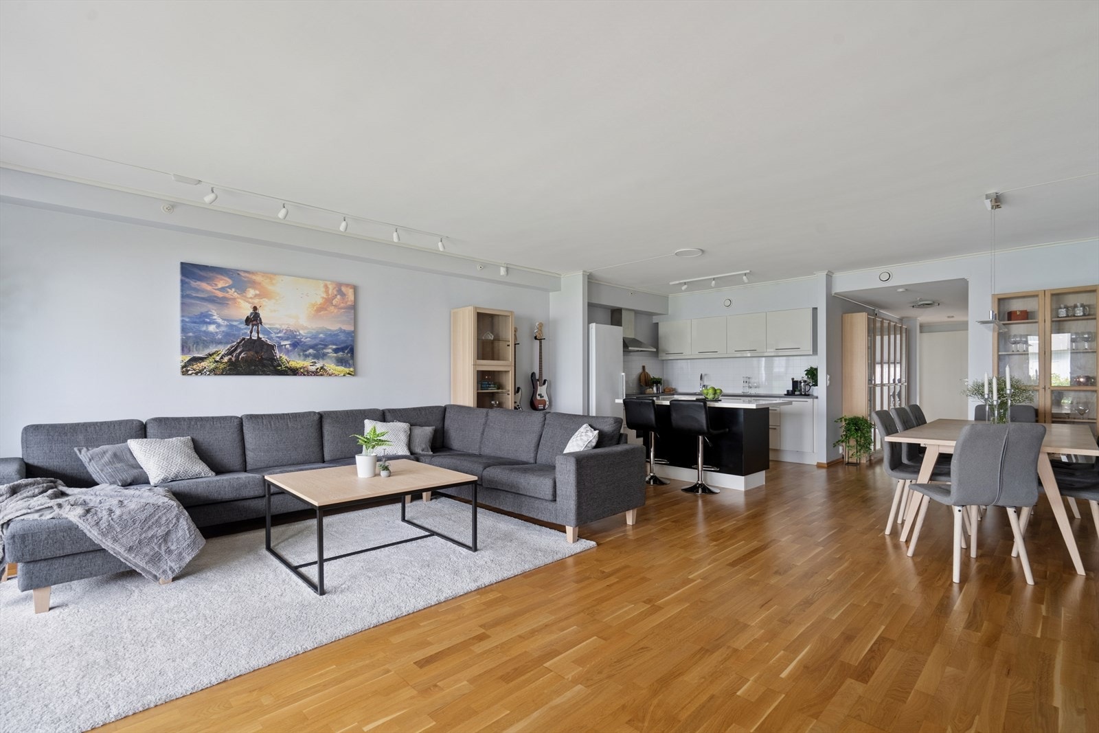 Stuen er en del av en åpen kjøkken- og stueløsning med store vindusflater som gir rikelig lys og utgang til en solrik terrasse. Galleribilde