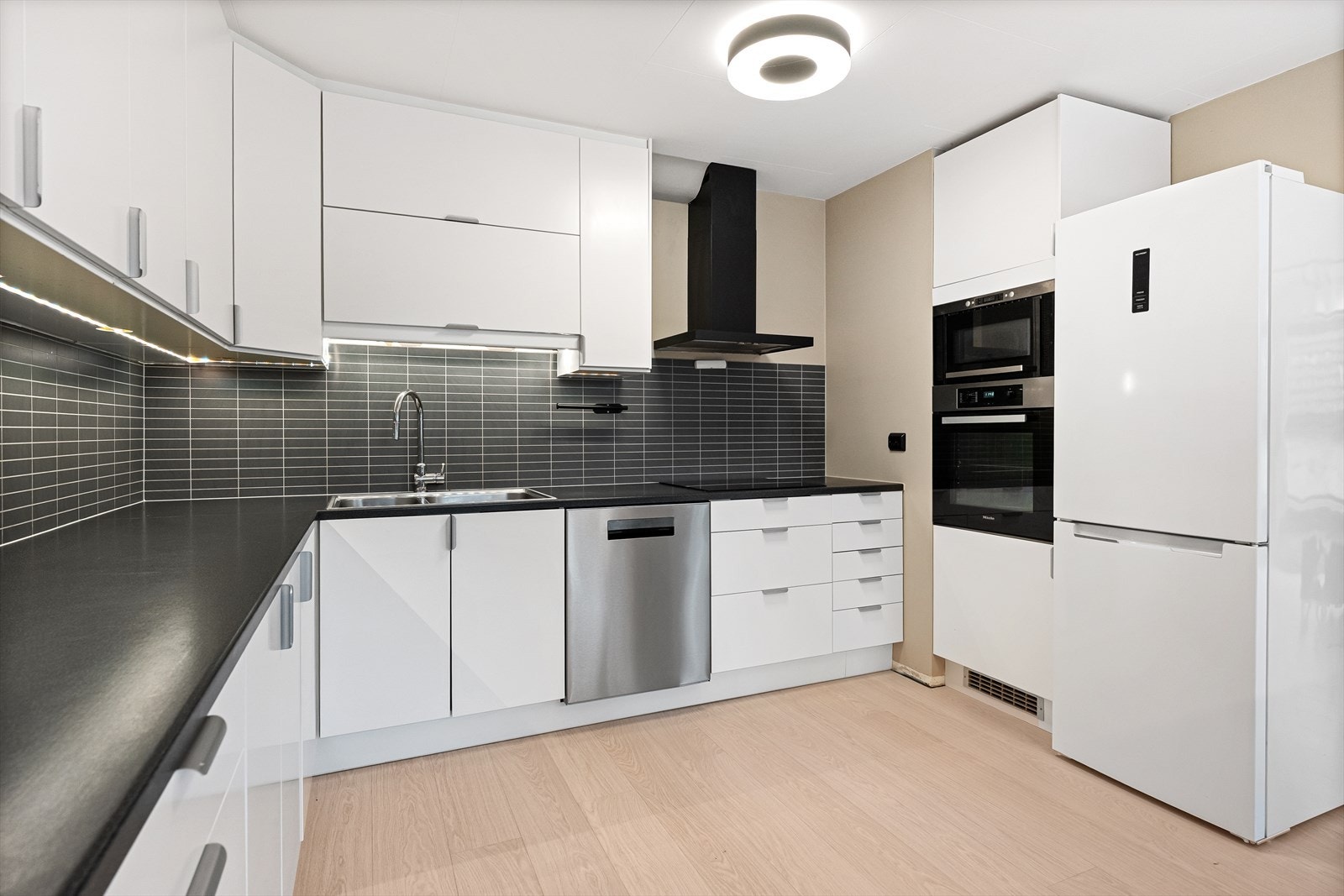 Moderne kjøkken med stilren design og funksjonelle løsninger. Godt med oppbevaringsplass. Galleribilde