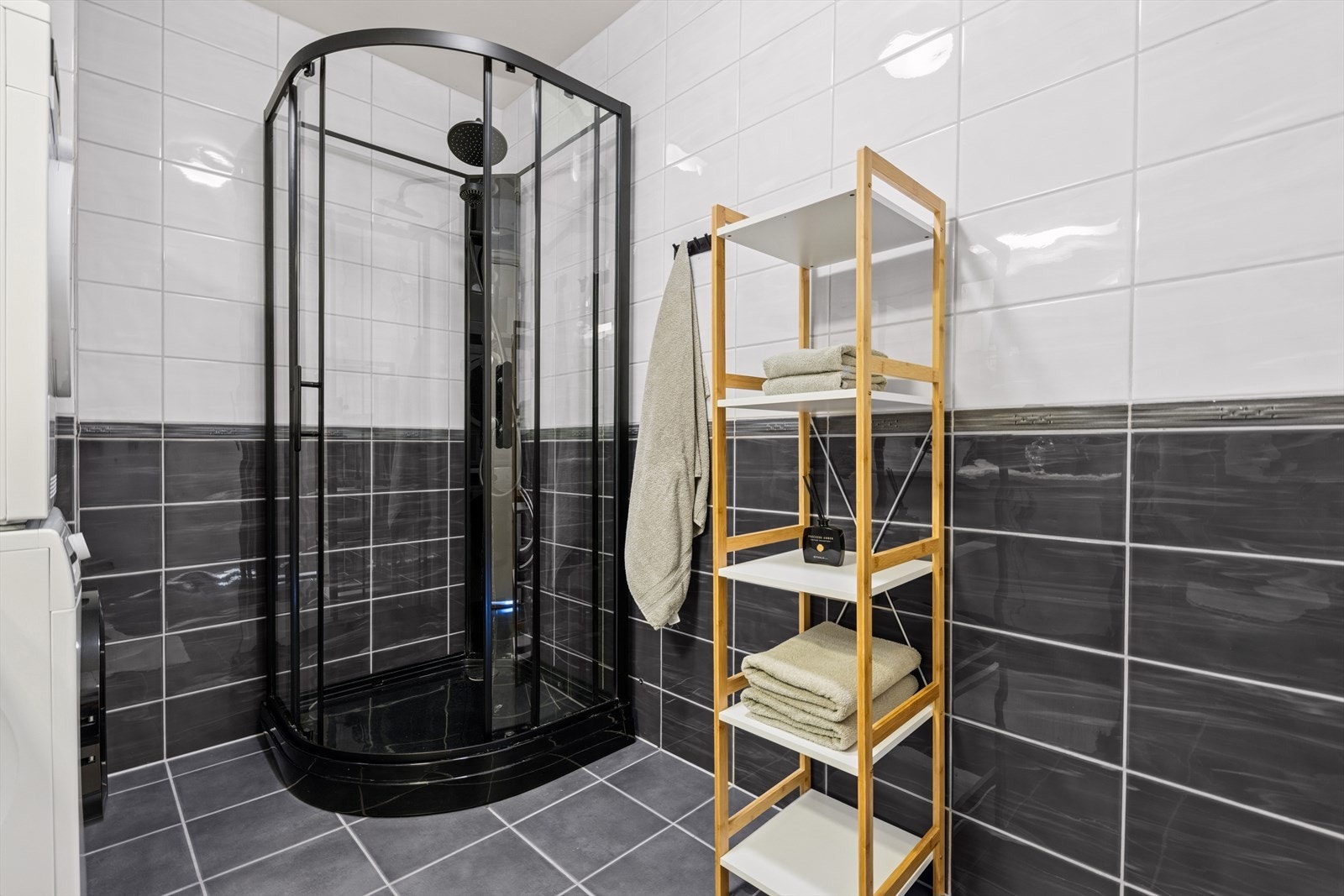 Badet er innredet med nedfelt servant på skapinnredning, dusjkabinett og vegghengt toalett. Det er opplegg for vaskemaskin. Galleribilde