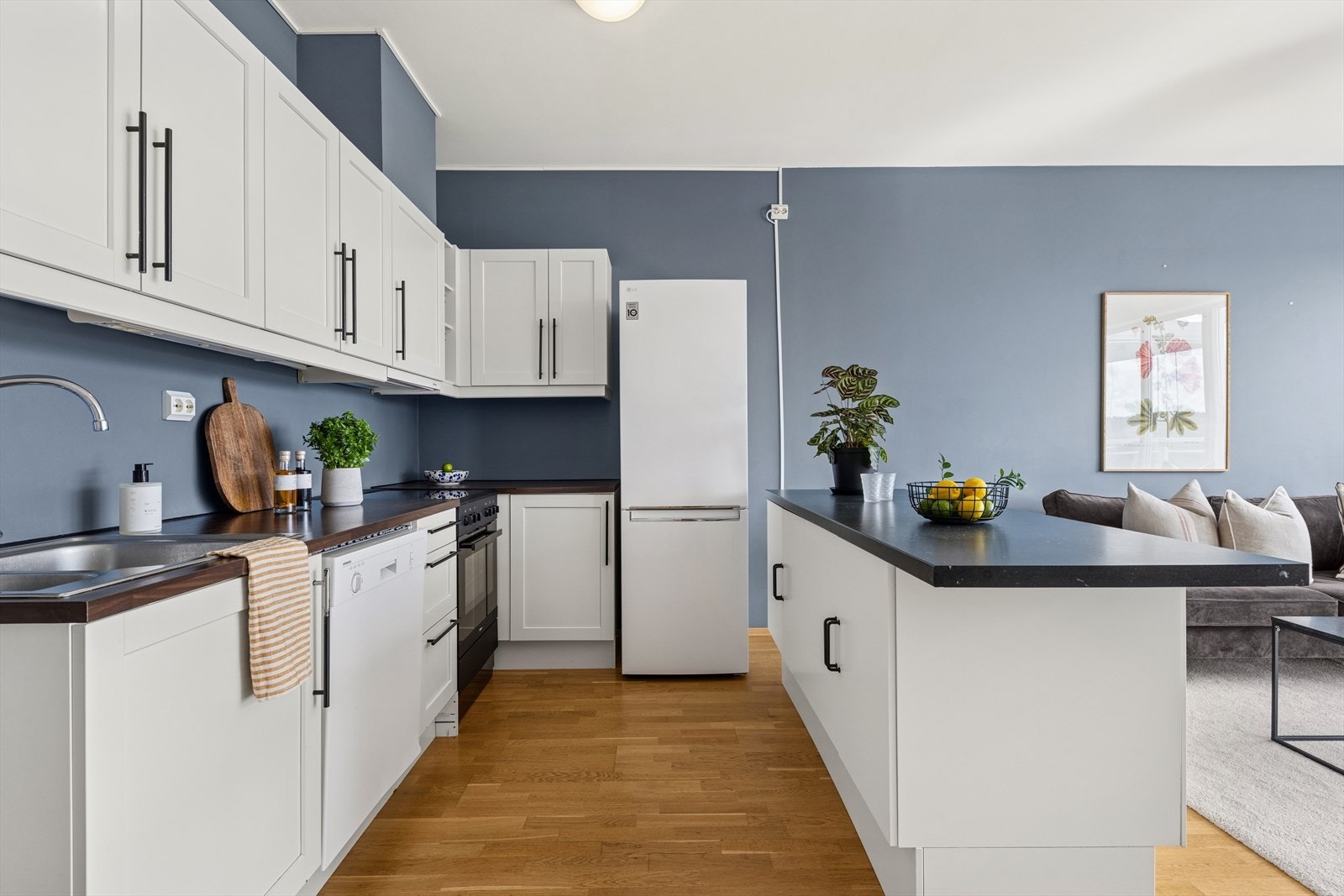 Kjøkkeninnredningen har hvite, profilerte fronter og mørk benkeplate i laminat i fin kontrast. Galleribilde