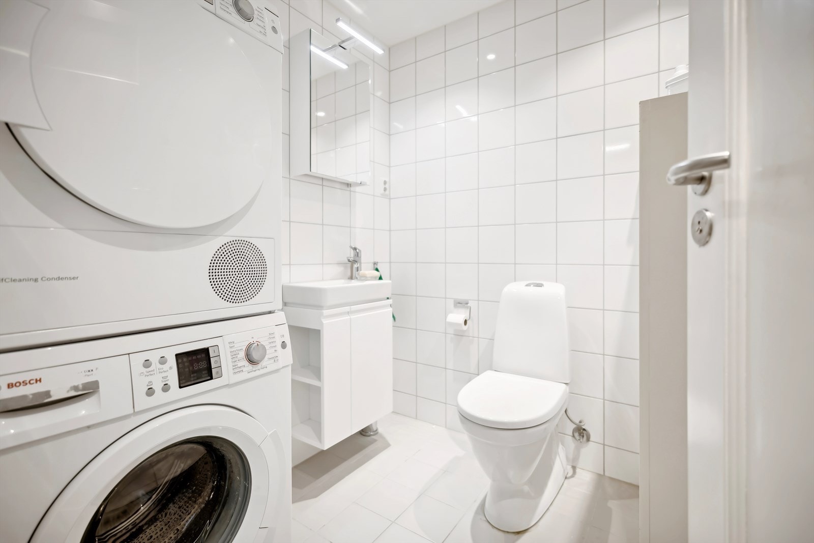 Ved entreen finner du et flislagt baderom som er både romslig og lyst, komplett med gulvvarme, moderne sanitærutstyr, og opplegg for vaskemaskin. Galleribilde