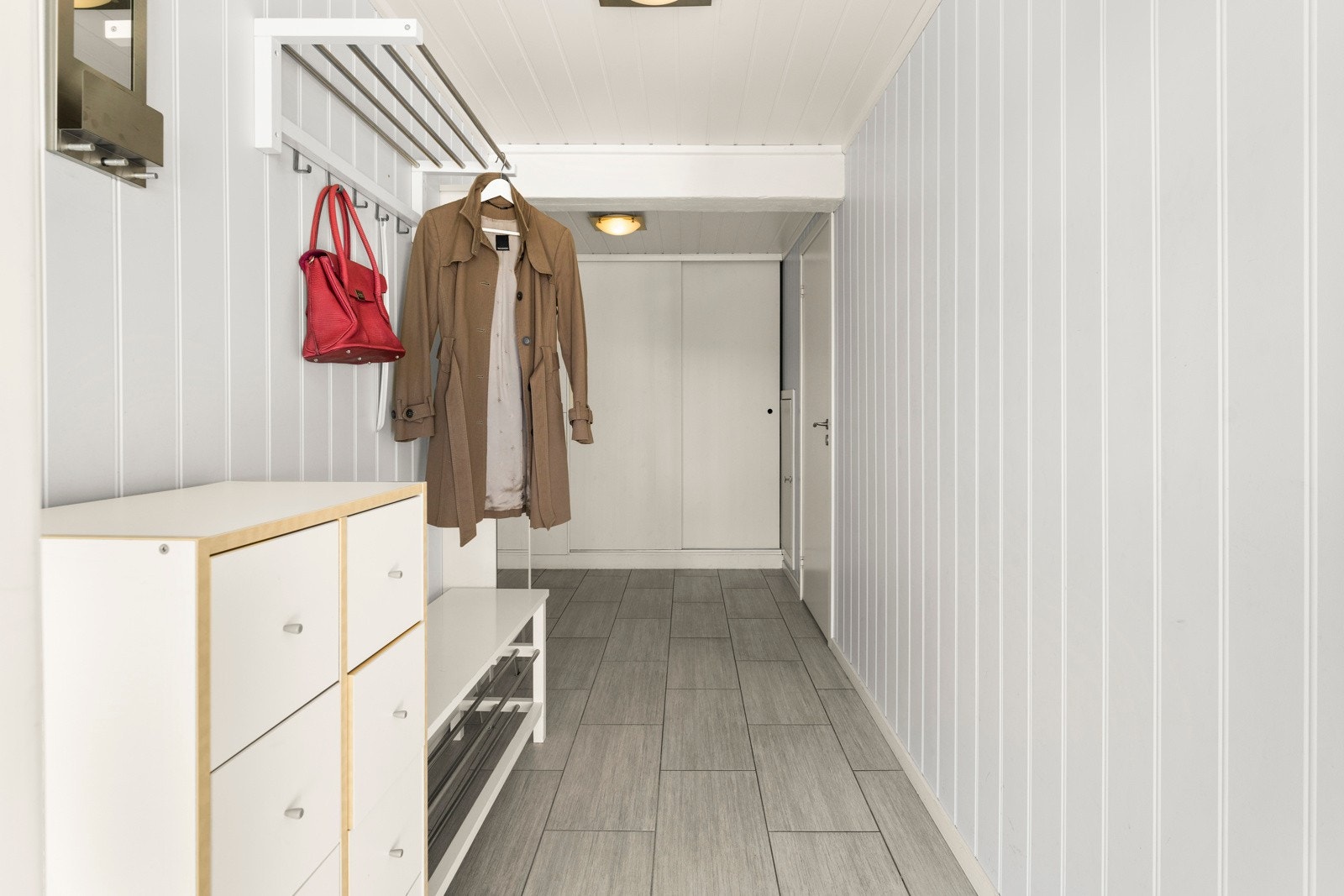 Entre med flislagt gulv og stor skyvedørsgarderobe Galleribilde