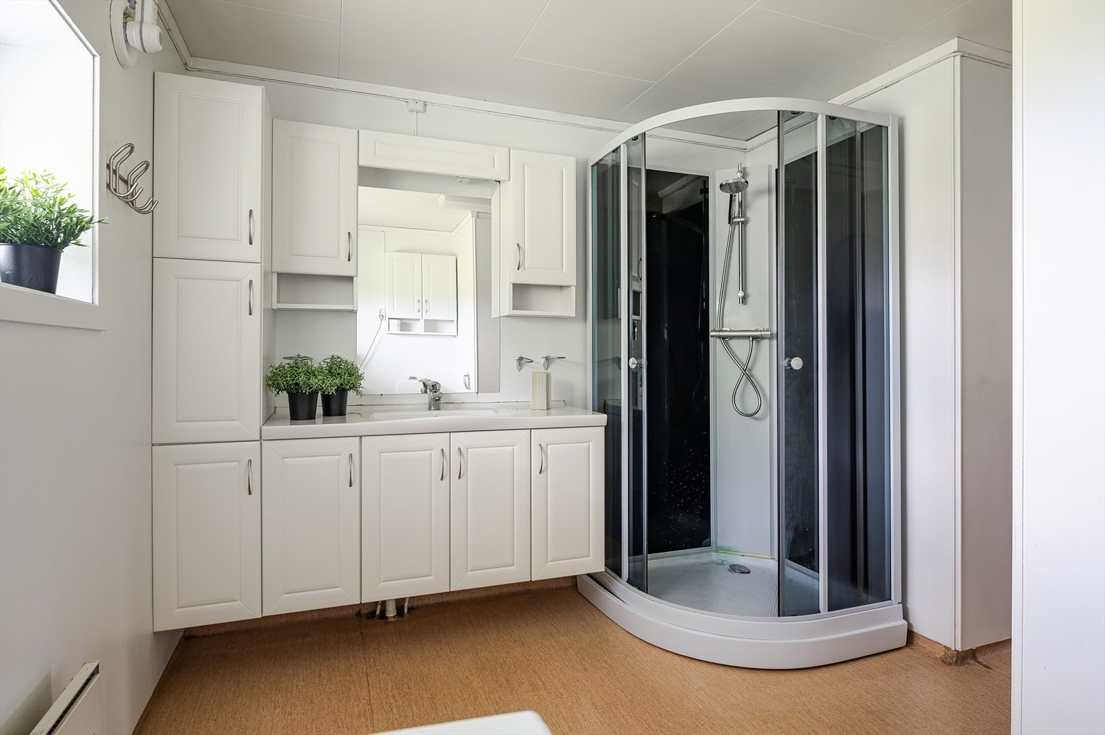 Badet har servant med skapplass, dusjkabinett, toalett og opplegg for vaskemaskin. Galleribilde