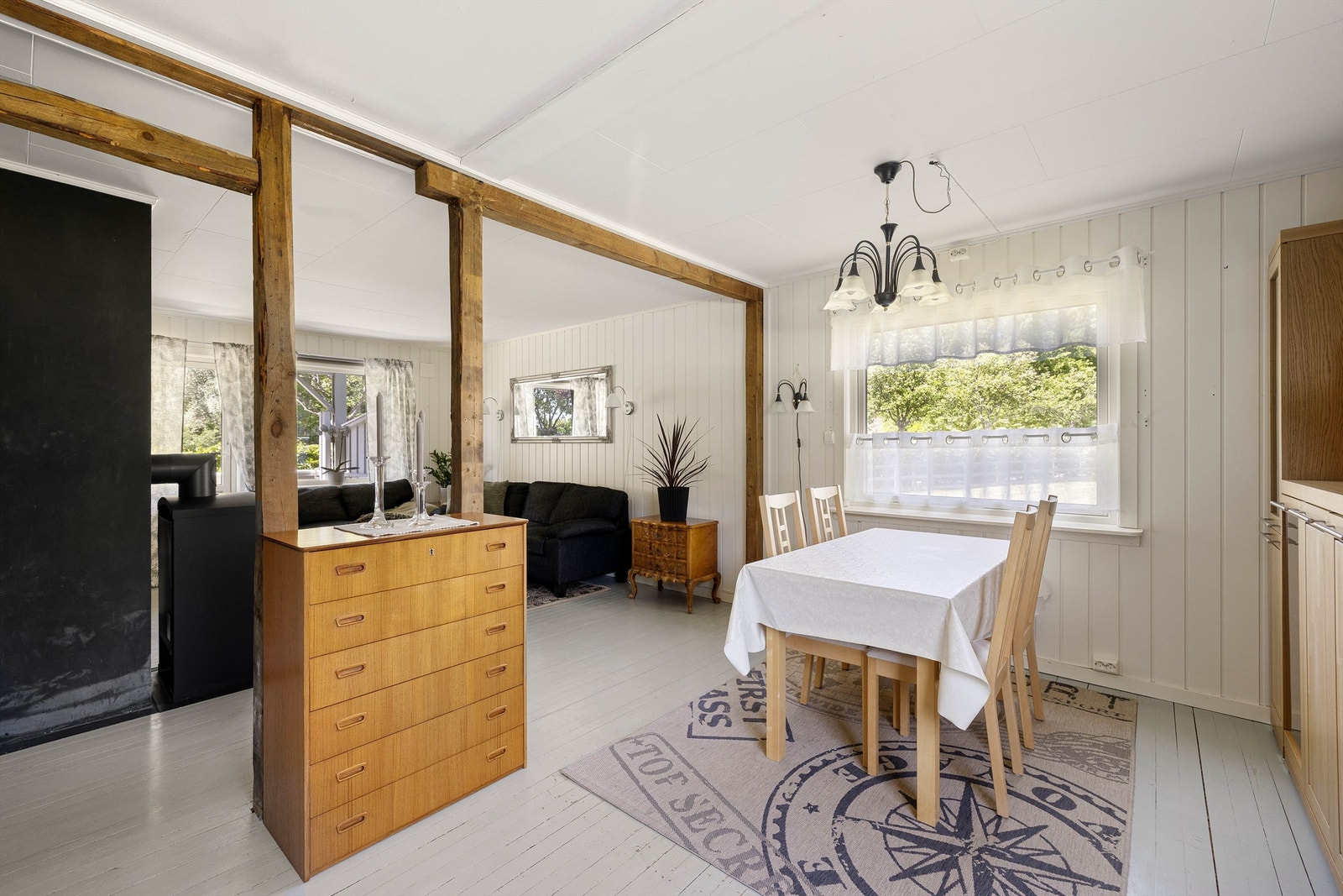 Trebjelkene som tidligere var innrammet av vegger er nå synlige og dekorative elementer som danner soner i den åpne romløsningen. Galleribilde