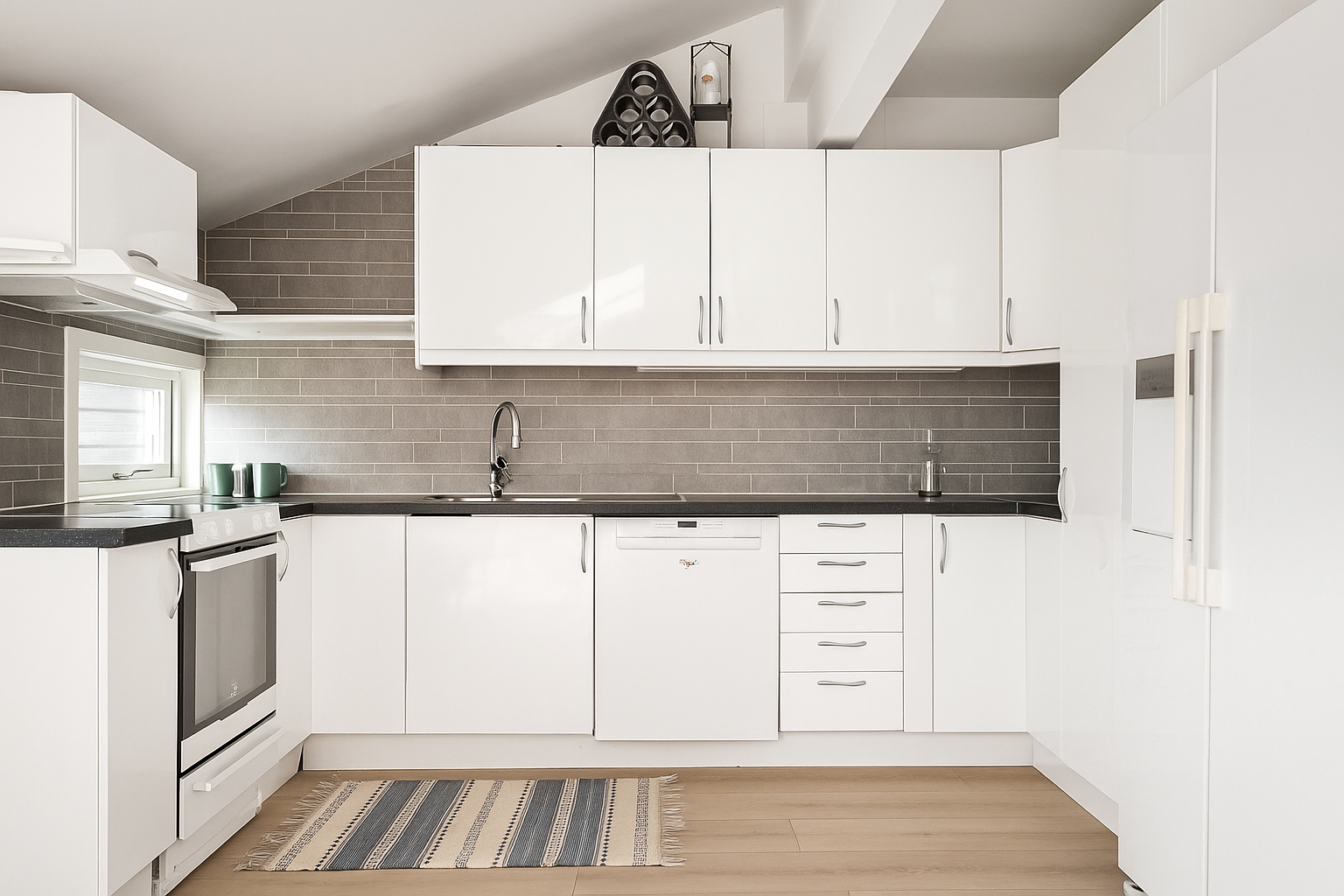 Praktisk kjøkken med hvite glatte fronter og laminert benkeplate. Galleribilde