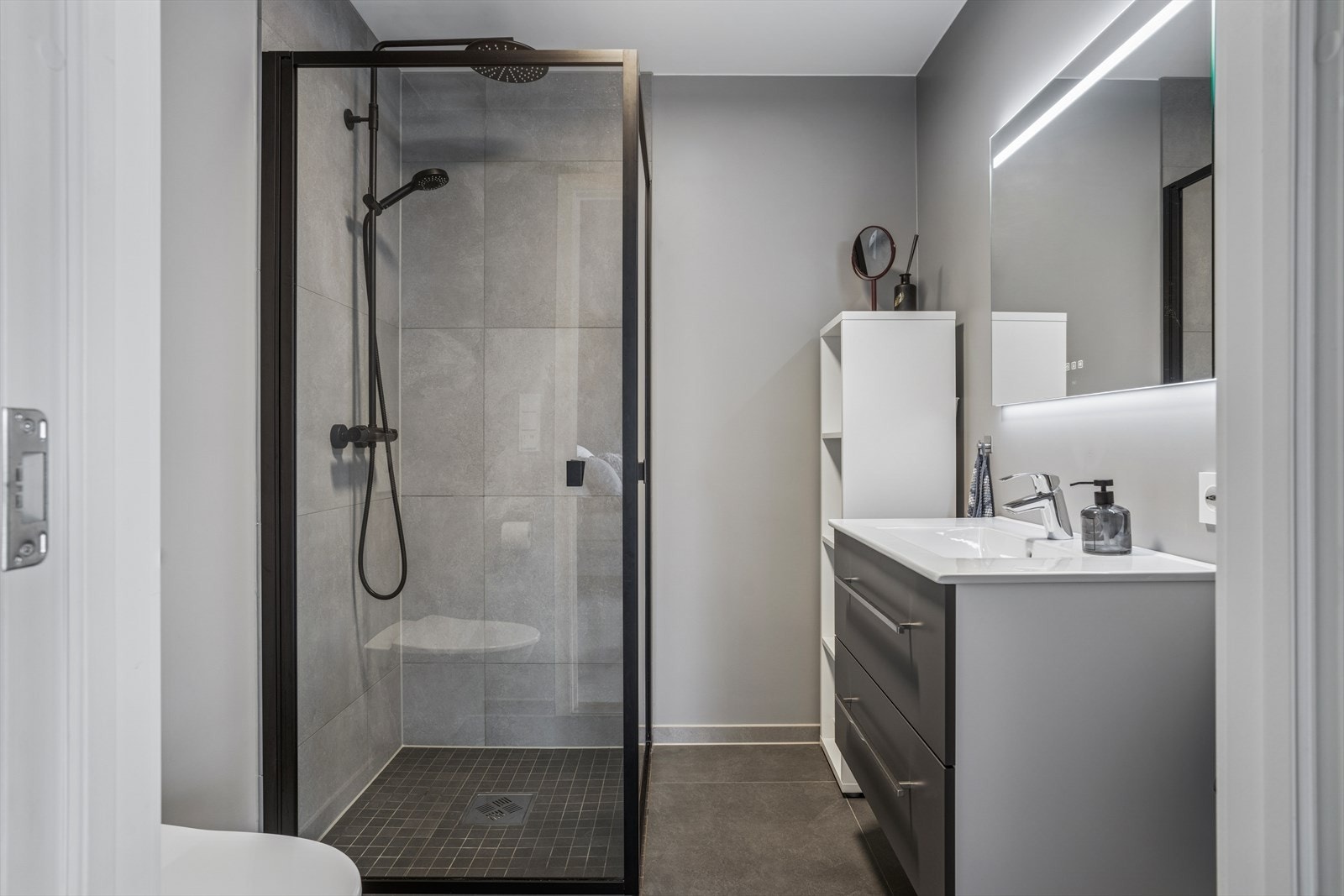 Bad tilknyttet hovedsoverommet er innredet med dusj, toalett, speil med lys og en seksjon med servant. Galleribilde