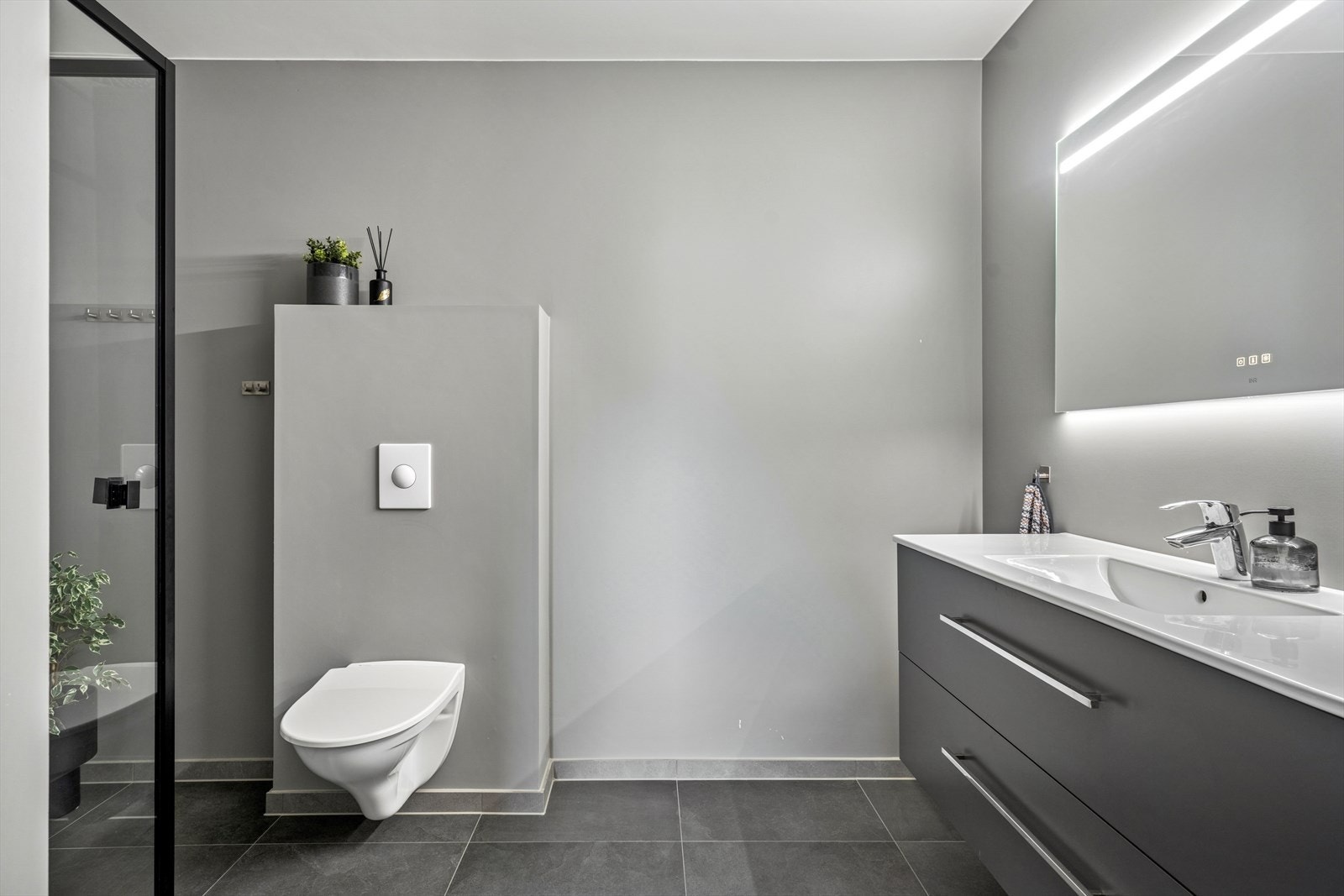 Hovedbadet i andre etasje er innredet med dusj, toalett, speil med lys og en seksjon med servant. Galleribilde