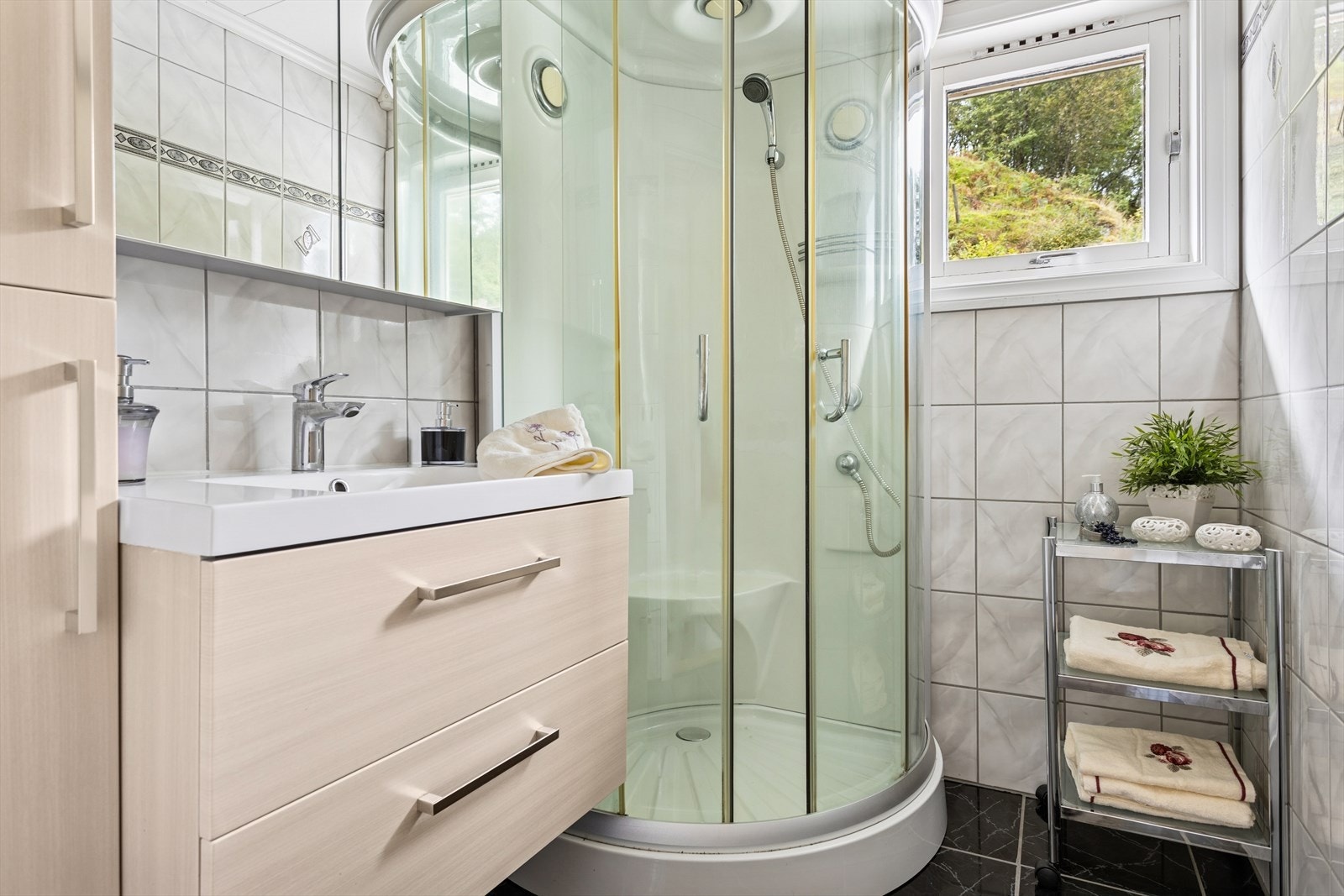 Badet er utstyrt med innredning med nedfelt servant og dusjkabinett, og har naturlig ventilasjon Galleribilde