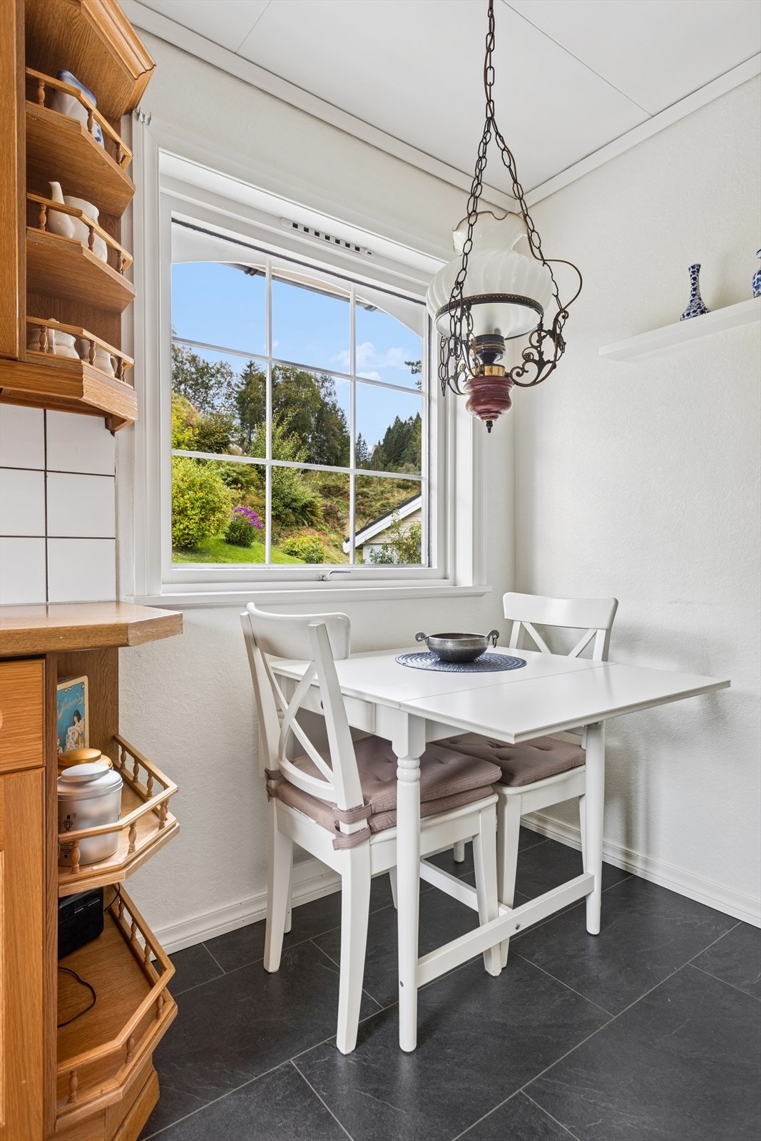 På kjøkkenet finner du en koselig spiseplass ved et stort vindu som slipper inn rikelig med dagslys og gir en fin utsikt mot omgivelsene Galleribilde