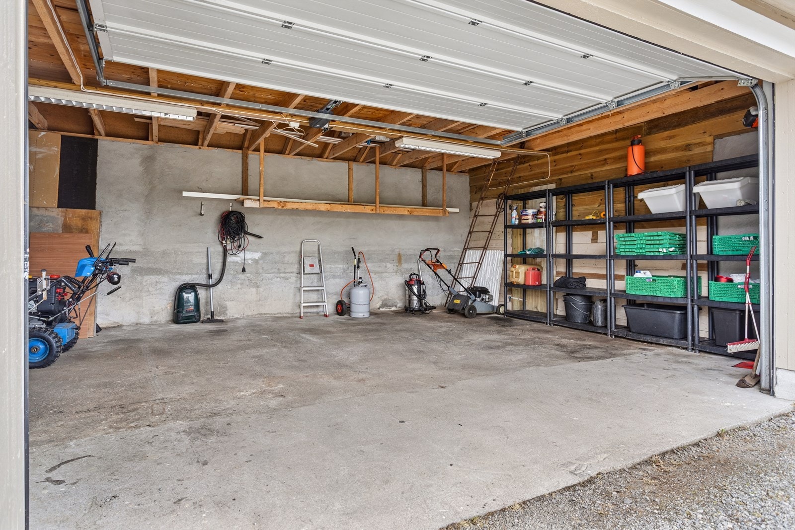 Romslig garasje med rikelig plass til både kjøretøy og praktiske oppbevaringsløsninger Galleribilde