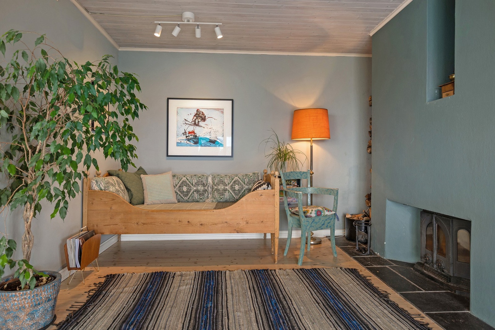 Her i stuen er det tregulv og en peis med innsats. Den ligger mellom spisestue og vinterhagen. Galleribilde