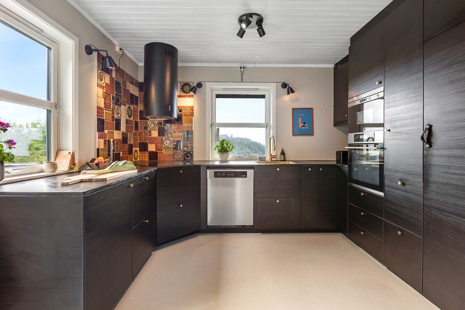 Kjøkkenet ligger innenfor spisestuen og har takhøye overskap Galleribilde