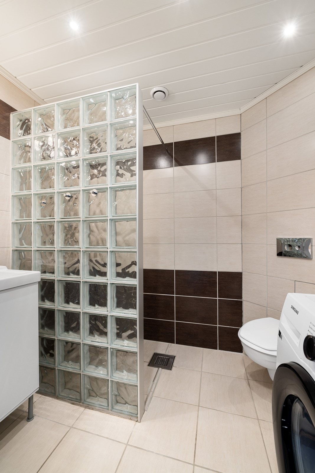 Flislagt bad med dusjnisje med glassbyggerstein. Galleribilde