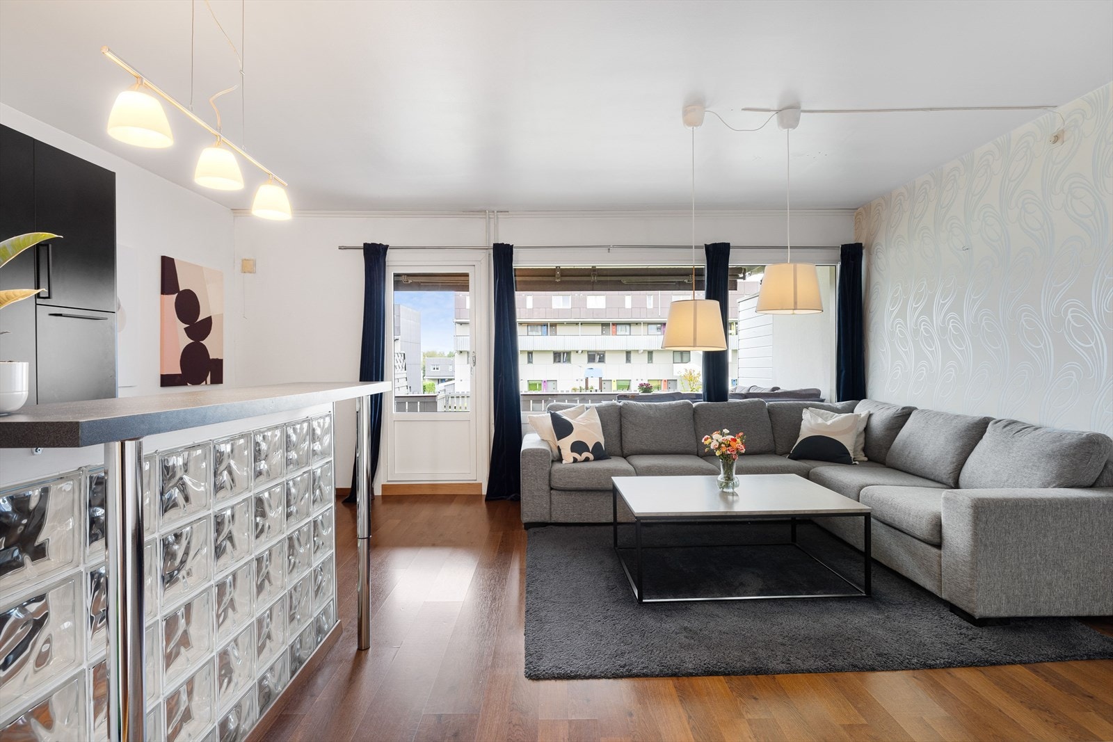 Leiligheten har en åpen stue- og kjøkkenløsning med lyse overflater. Galleribilde