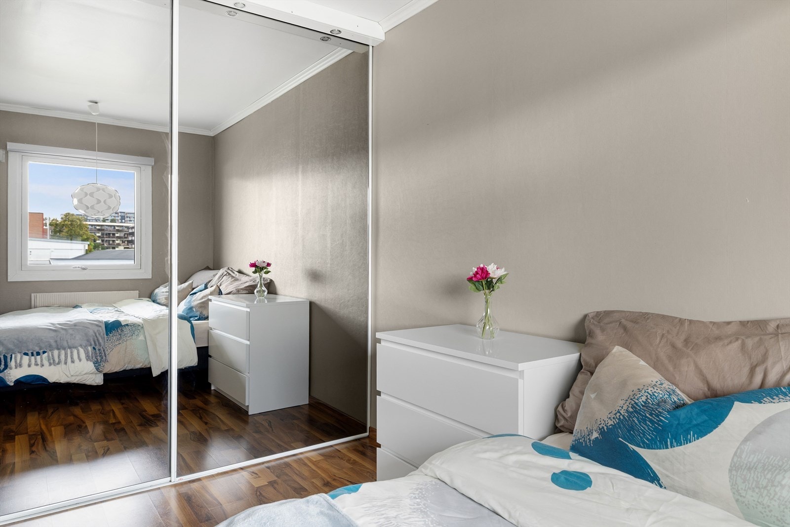 Det er montert en romslig skyvedørsgarderobe med speilfronter og lys i toppen. Galleribilde