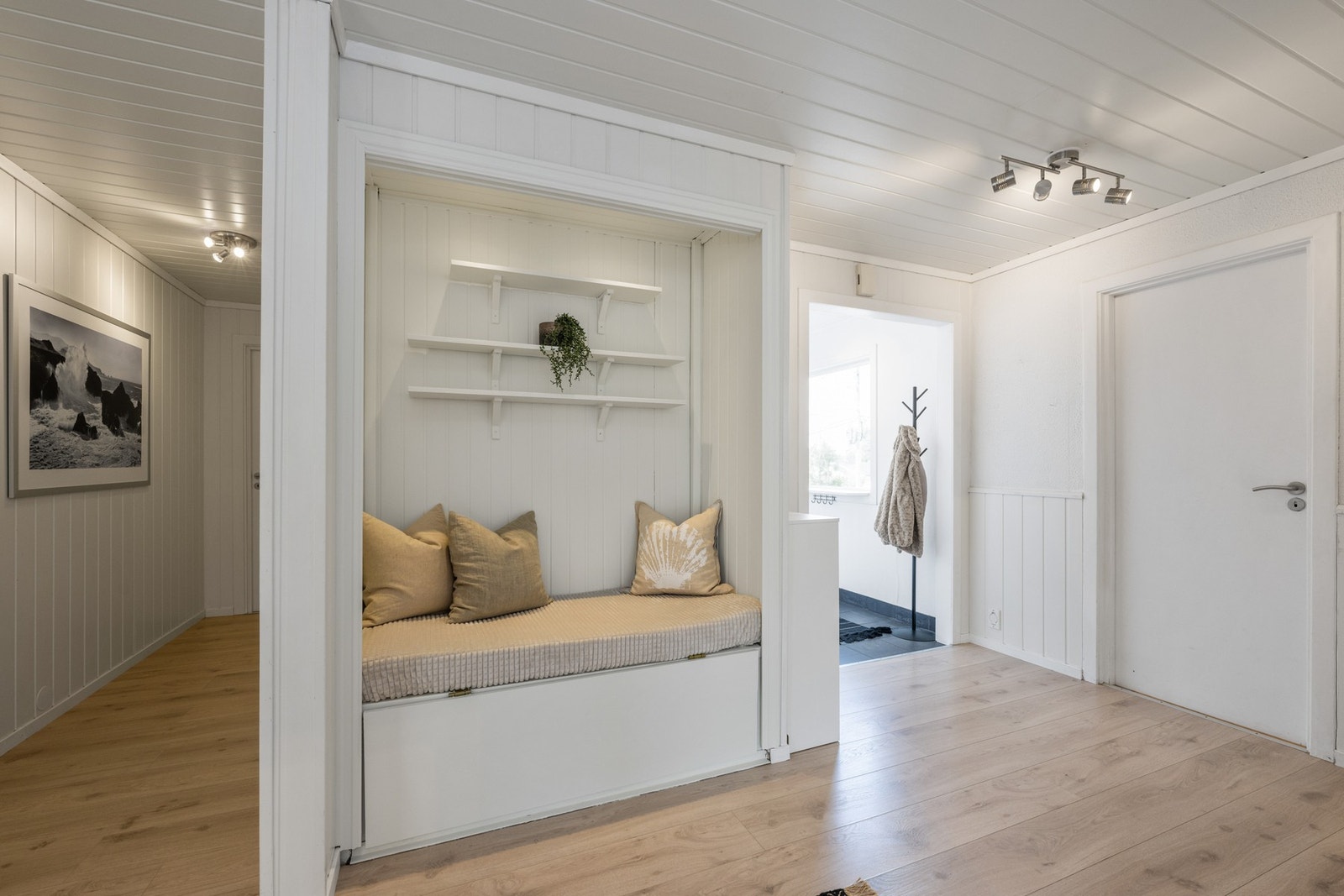 I en nisje har gangen hyller og sittebenk med oppbevaringsmuligheter. Galleribilde