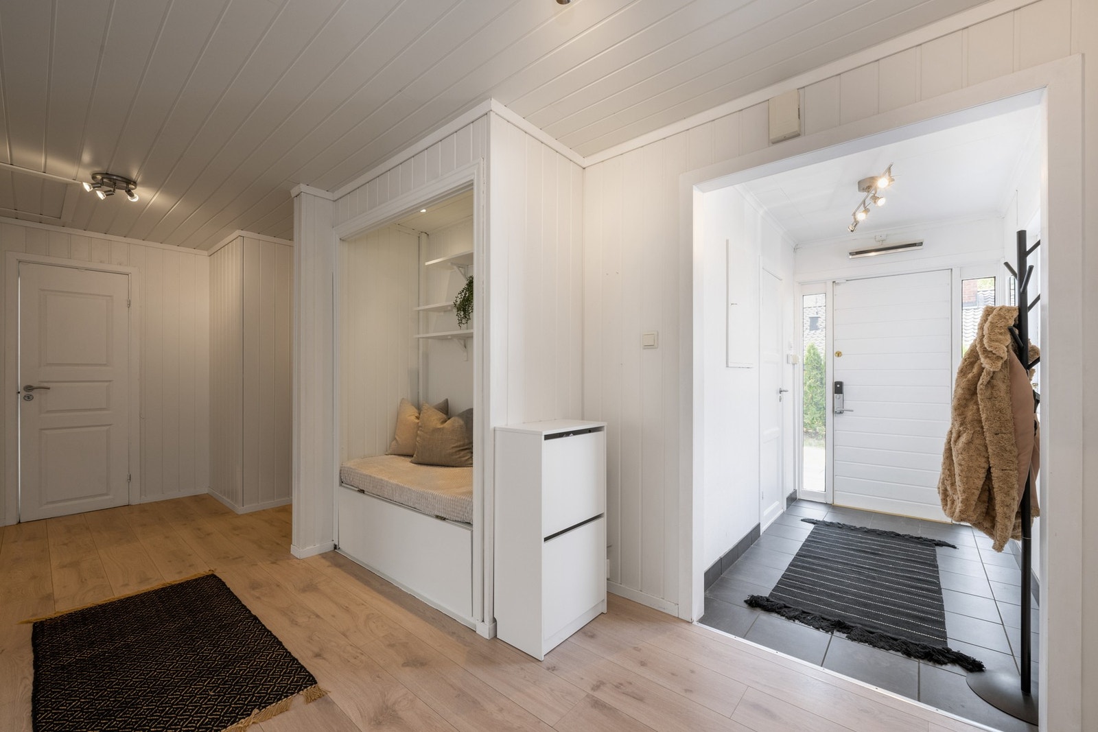 Vel inne er det plass til å henge fra seg yttertøyet i en lys entré med flislagt gulv. Galleribilde