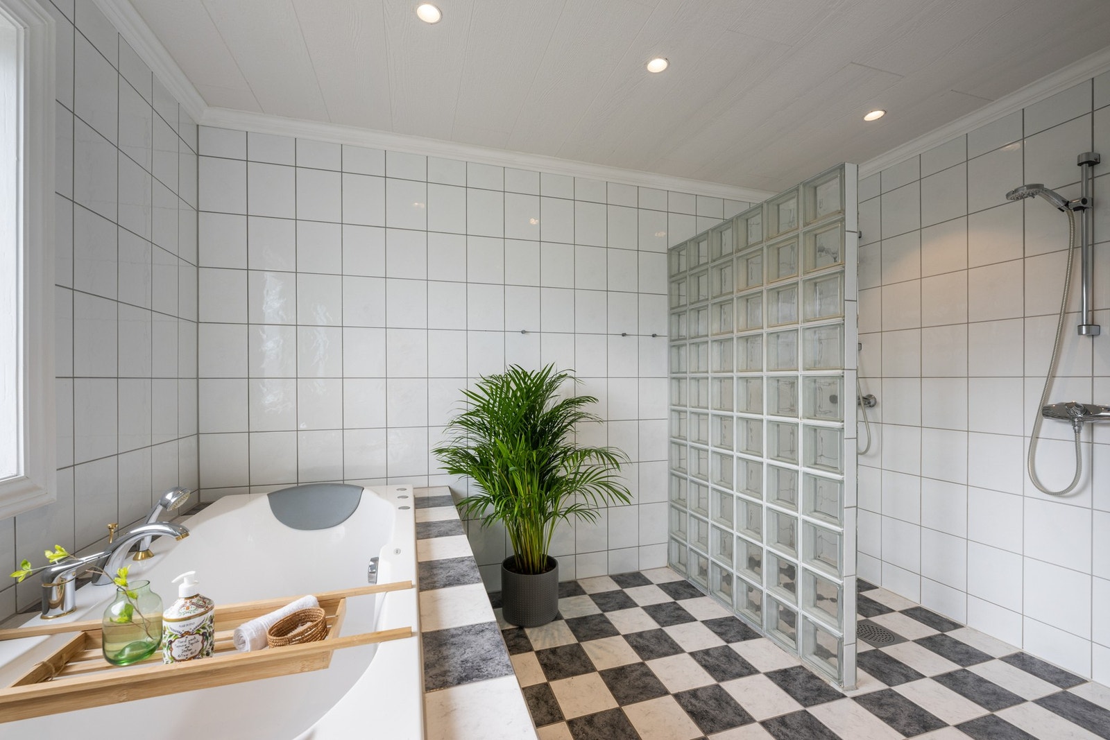 Varme er lagt i gulvet, og badet har toalett, downlights og et dobbelt dusjhjørne med vegg av glassbyggerstein. Galleribilde