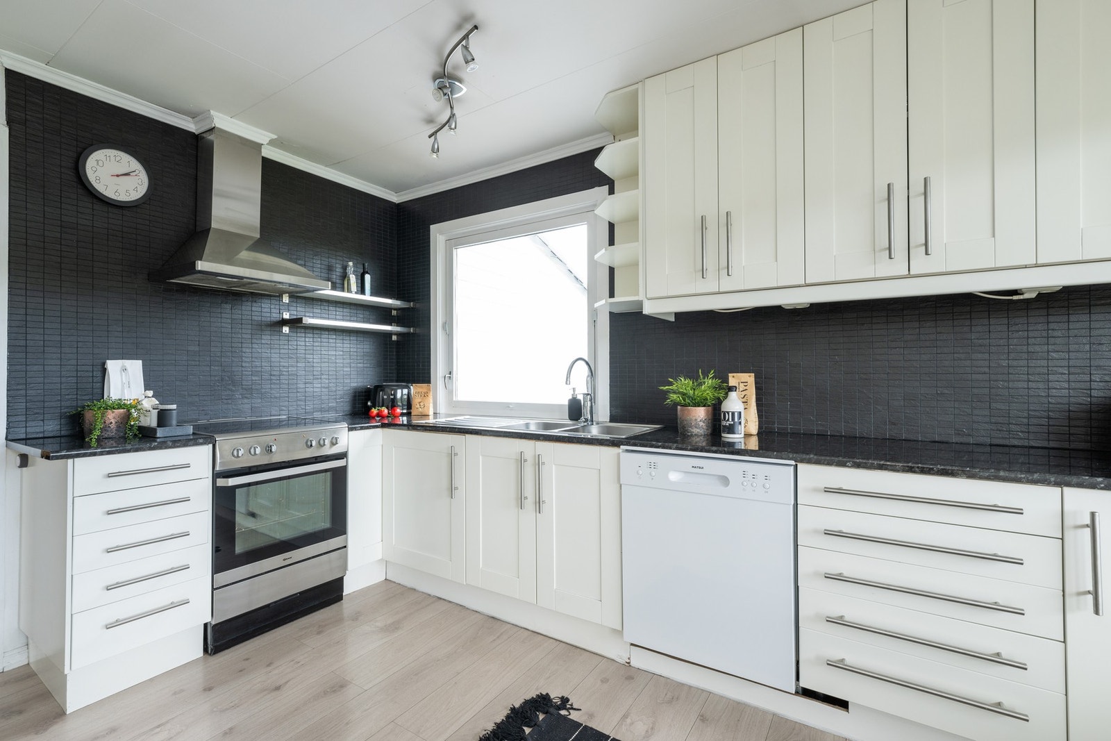 Selve kjøkkenet består av en funksjonell L-form med god skapplass, supplert av to praktiske høyskap for ekstra oppbevaring. Galleribilde