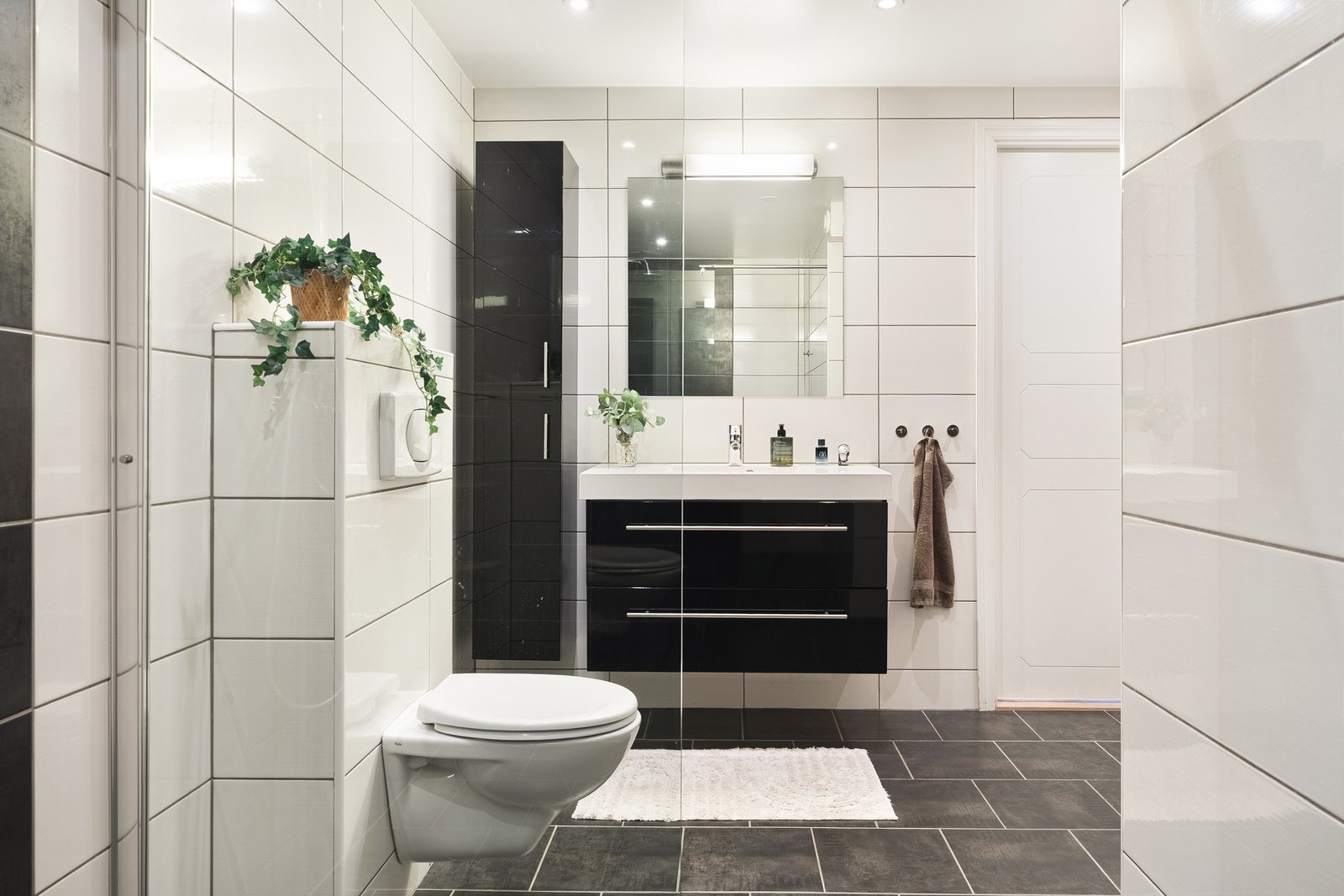Badet er av god størrelse og er innredet med vegghengt toalett, servant med innredning, høyskap til oppbevaring og dusjnisje med glassdør. Galleribilde