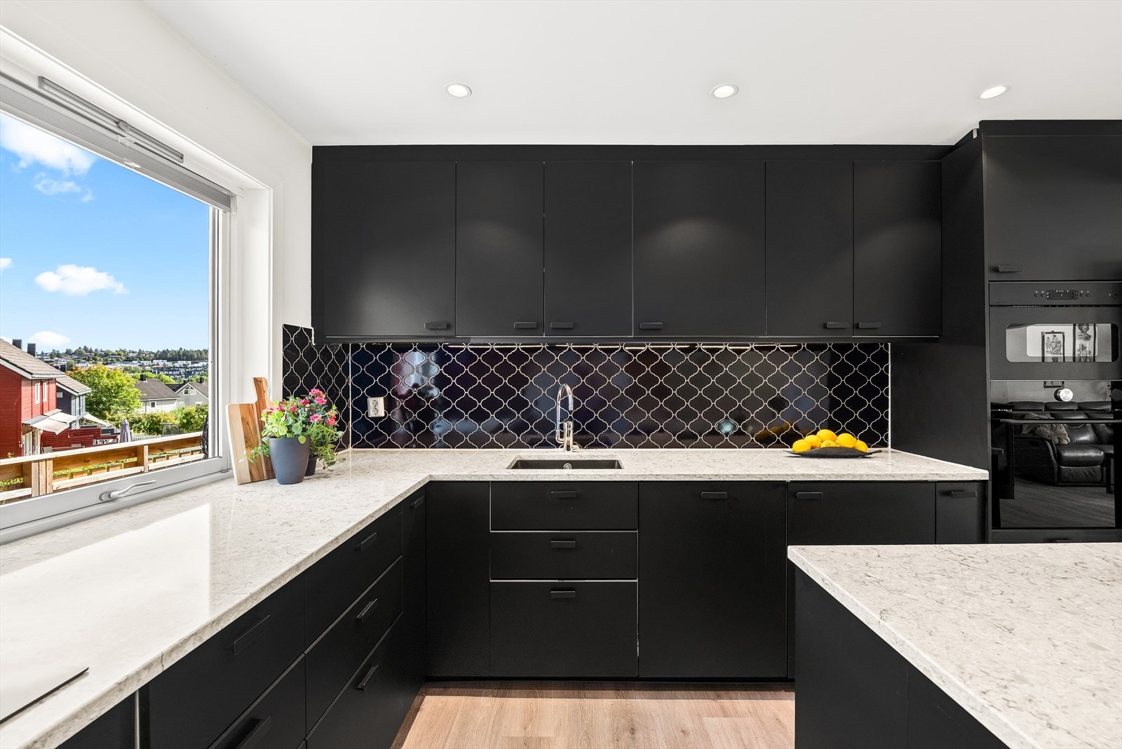 Kjøkkeninnredning med under-/overskap, slette fronter, benkeplate av steinkompositt e.l med underlimt kum i kompositt og ett-greps blandebatteri. Galleribilde