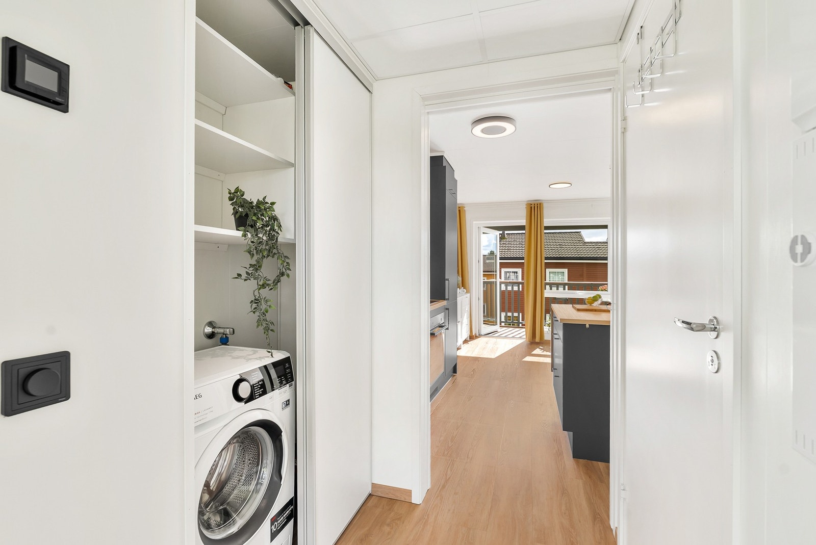 Praktisk skyvedørsgarderobe med opplegg for vaskemaskin. Galleribilde