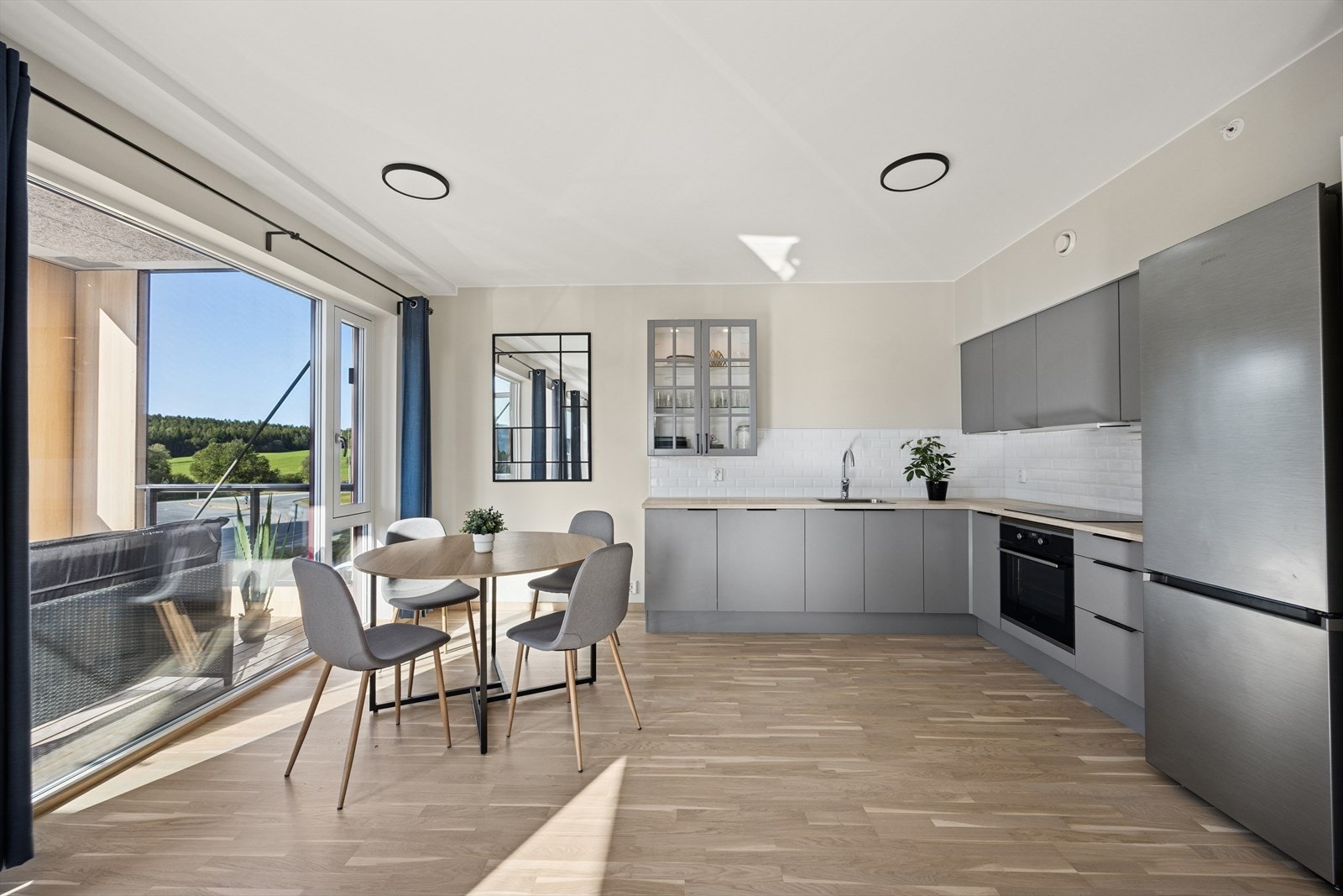 Lys og luftig kjøkkenløsning med store vinduer som slipper inn rikelig med naturlig lys og gir en herlig romfølelse. Galleribilde