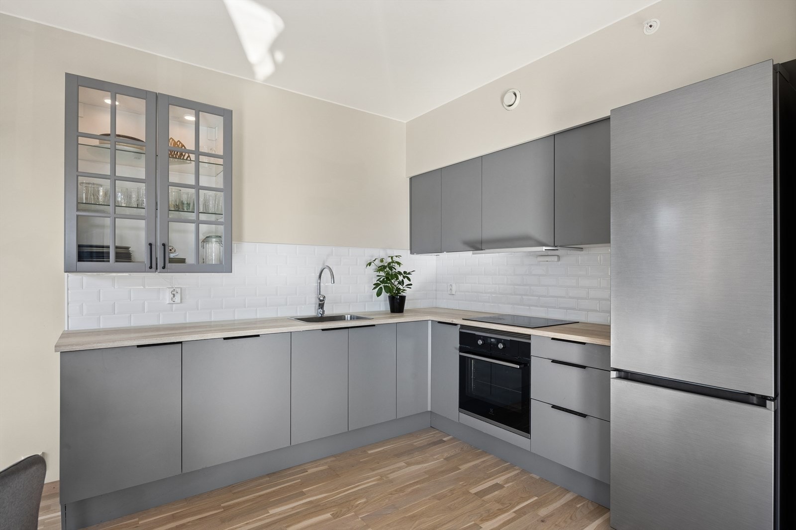 Moderne kjøkken med integrerte hvitevarer, stilrene overflater og godt med benk- og skapplass. Galleribilde