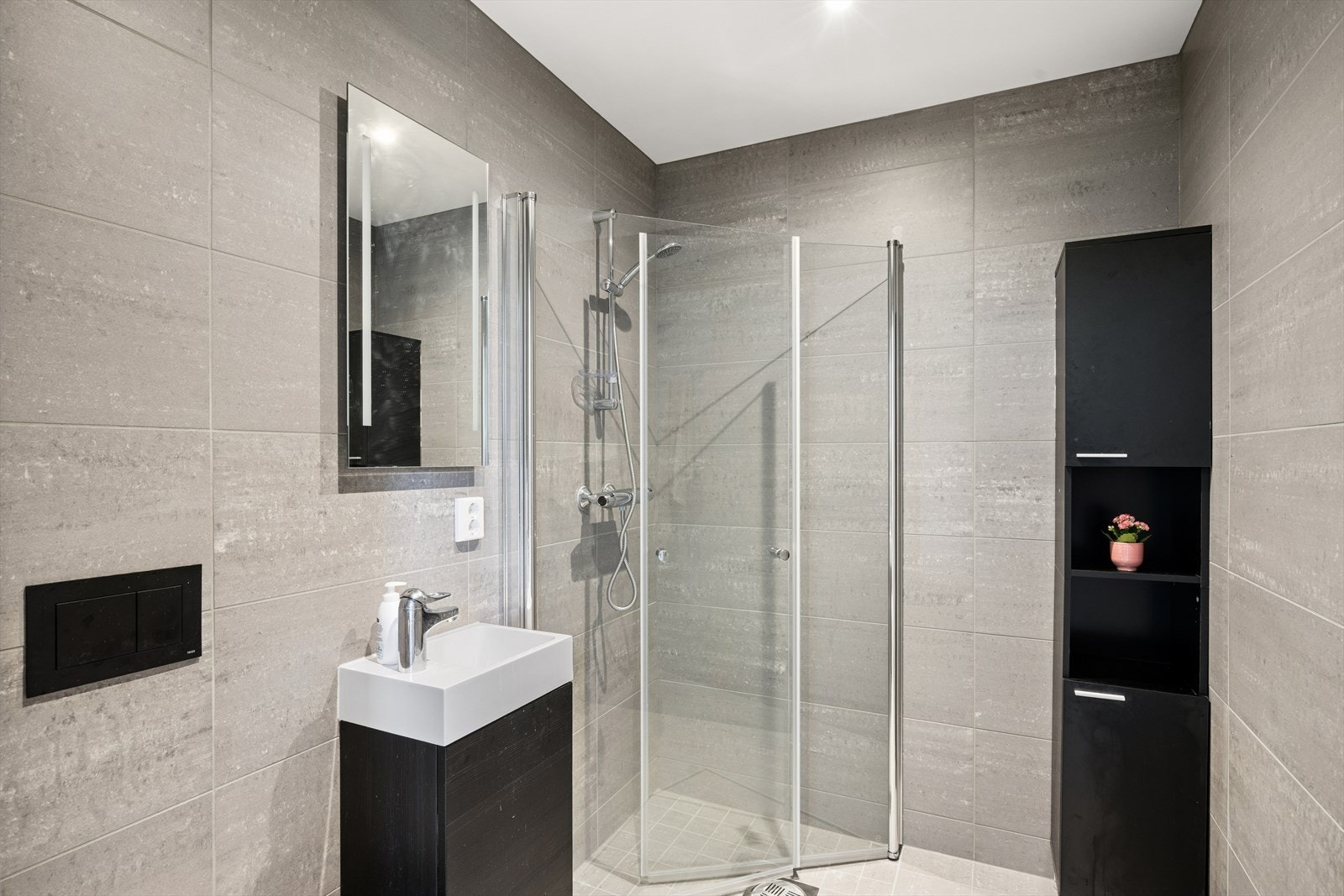 Badet til soverommet har et moderne fargevalg med muligheter for oppbevaring. Galleribilde