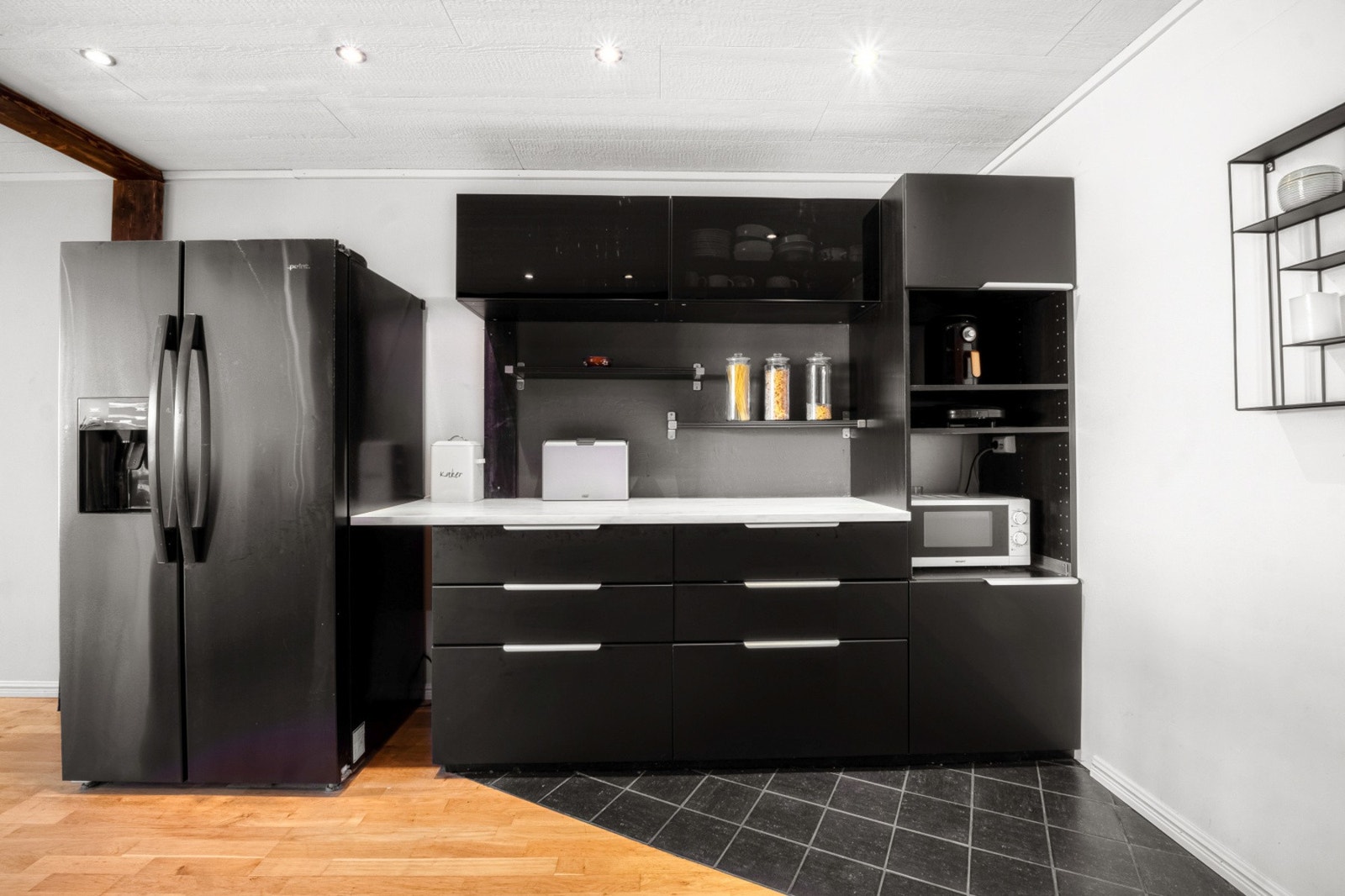 Benkeplate av laminat, nedfelt oppvaskkum og frittstående hvitevarer. Galleribilde